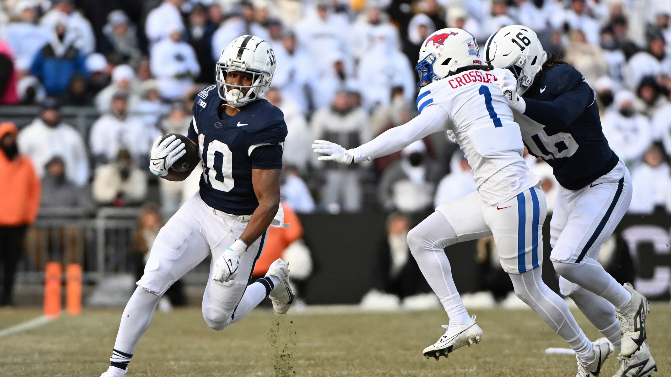 Penn State running back Nicholas Singleton looks to elude SMU safety Brandon Crossley (1) during the first half in the first round of the College Football Playoff, Saturday, Dec. 21, 2024, in State College, Pa. (AP Photo/Barry Reeger)