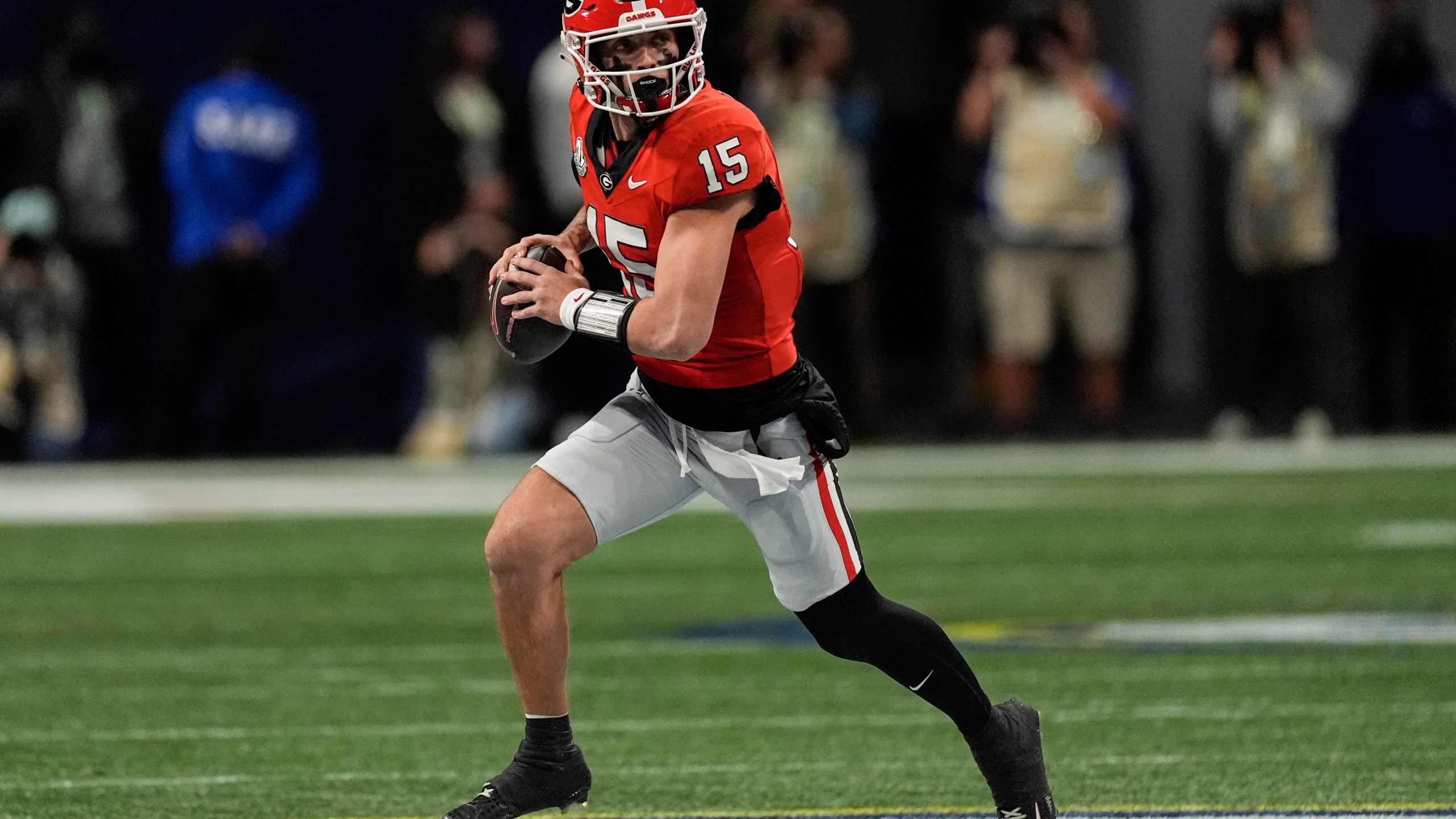 Georgia quarterback Carson Beck (15) runs out of the pocket against Texas during the first half of the Southeastern Conference championship NCAA college football game, Saturday, Dec. 7, 2024, in Atlanta. (AP Photo/John Bazemore)