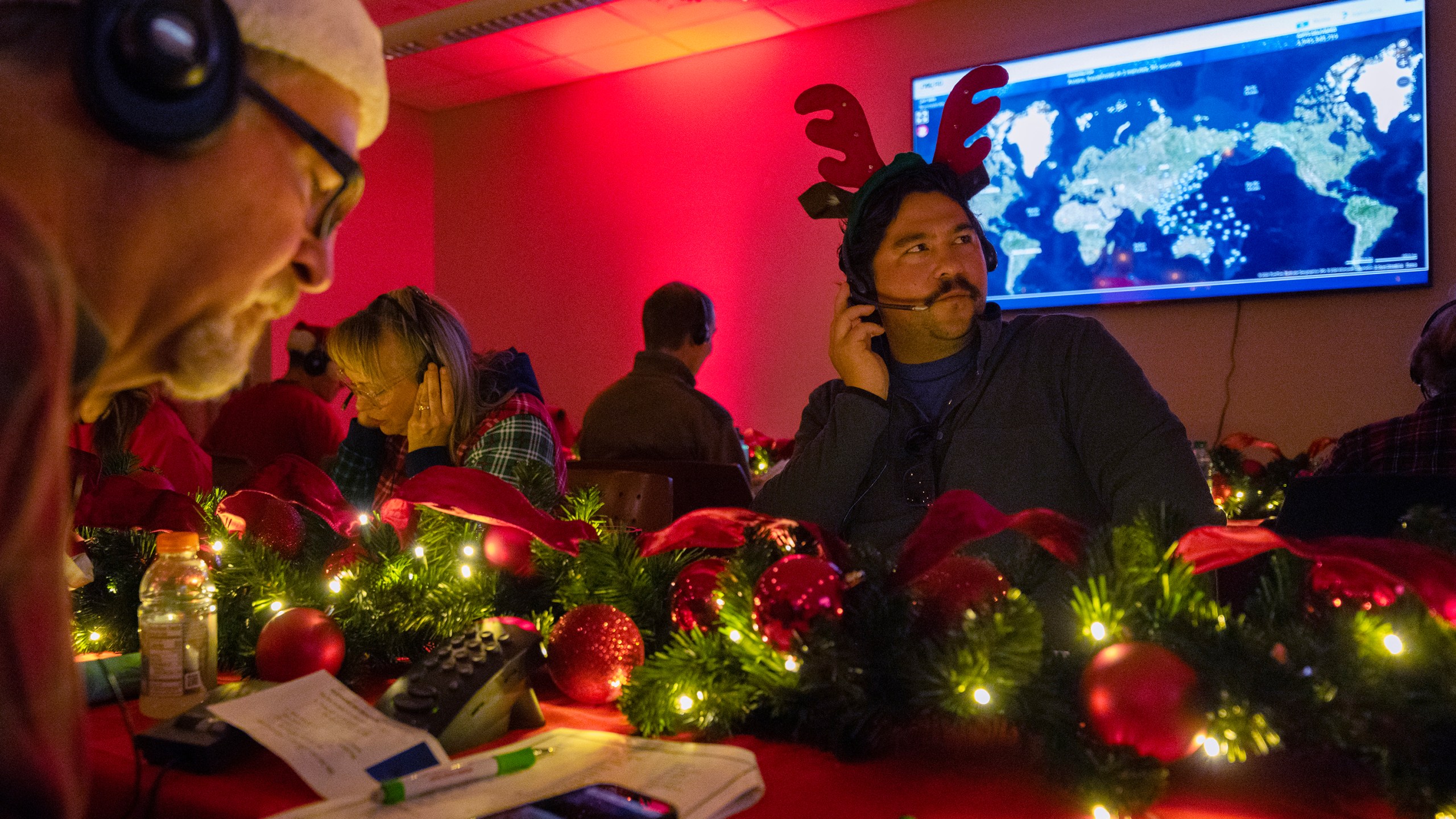 Volunteers answer phone calls from around the world Tuesday, Dec. 24, 2024, at the NORAD Tracks Santa center at Peterson Space Force Base in Colorado Springs, Colo. (Christian Murdock /The Gazette via AP)