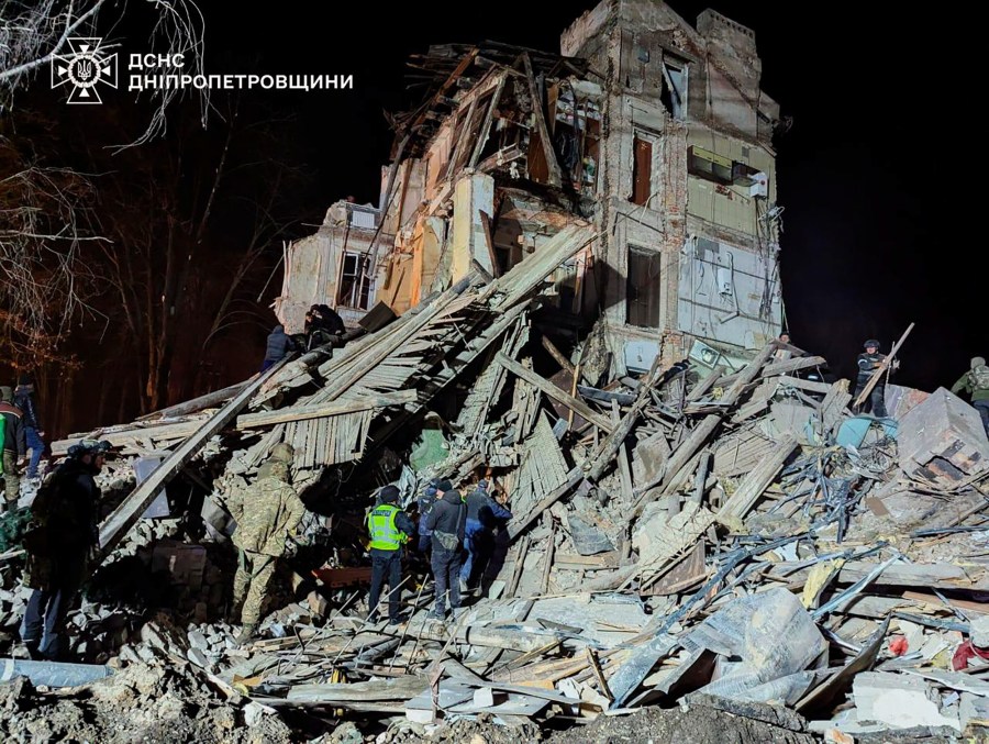 In this image provided by the Ukrainian Emergency Service on Wednesday, Dec. 25, 2024, firefighters work on a site of an apartment building destroyed by a Russian attack in Kryvyi Rih, Ukraine. (Ukrainian Emergency Service via AP)