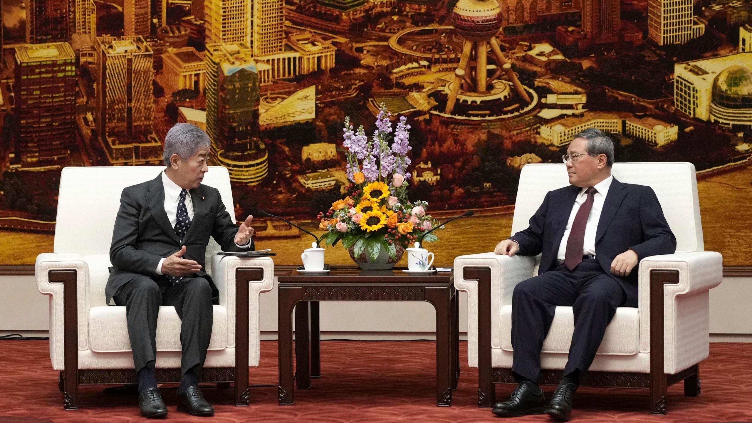 Japan's Foreign Minister Takeshi Iwaya, left, and Chinese Premier Li Qiang, right, hold a talk at the Great Hall of the People in Beijing Wednesday, Dec. 25, 2024. (Kyodo News via AP)