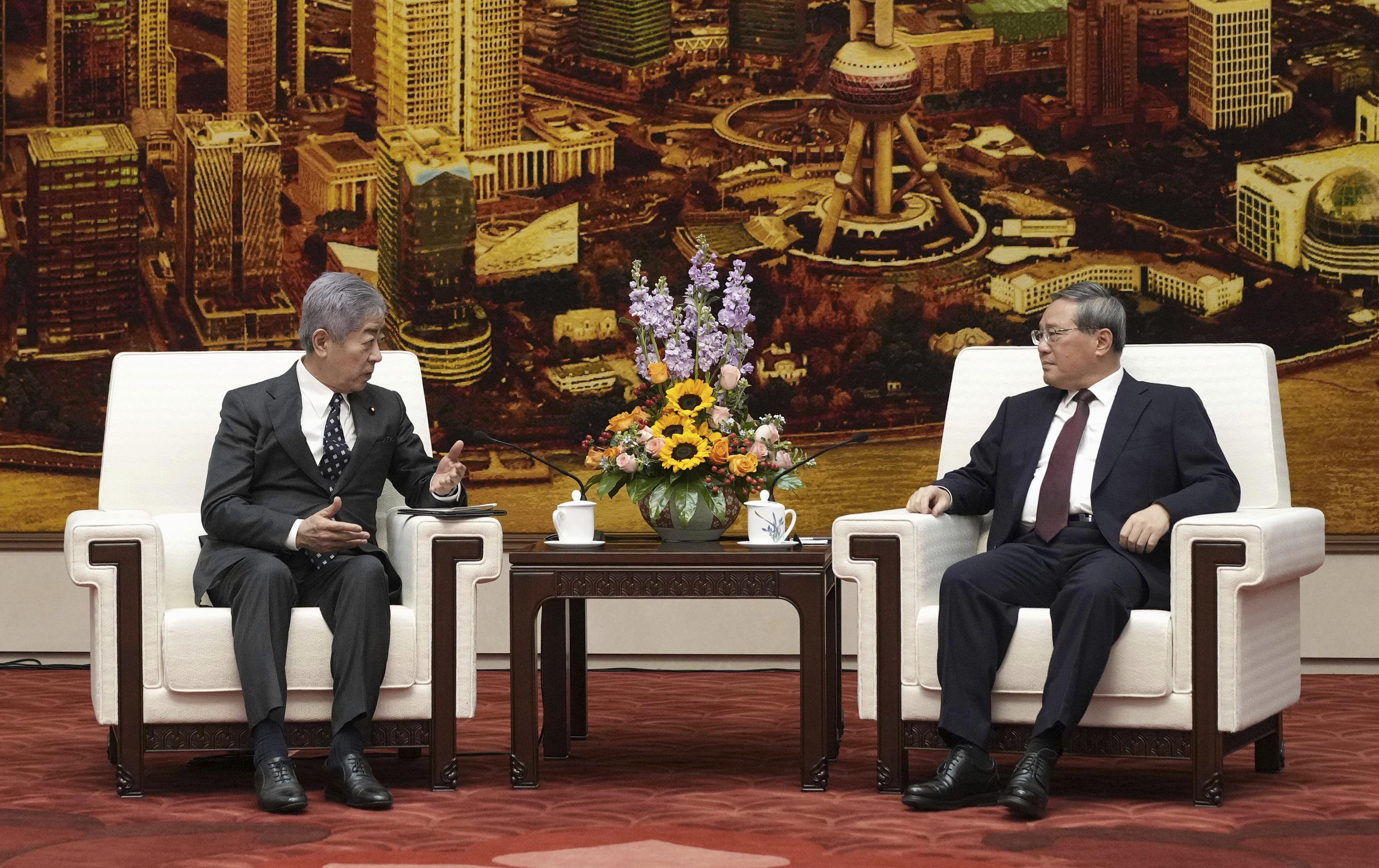 Japan's Foreign Minister Takeshi Iwaya, left, and Chinese Premier Li Qiang, right, hold a talk at the Great Hall of the People in Beijing Wednesday, Dec. 25, 2024. (Kyodo News via AP)