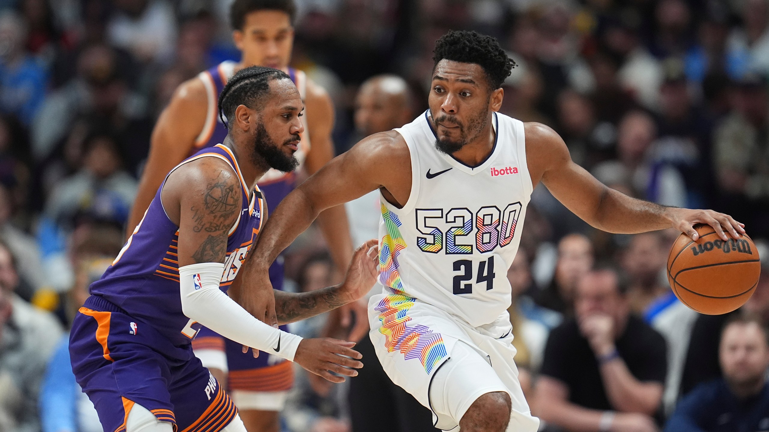 Denver Nuggets guard Jalen Pickett, right, drives past Phoenix Suns guard Monte Morris in the second half of an NBA basketball game Monday, Dec. 23, 2024, in Denver. (AP Photo/David Zalubowski)