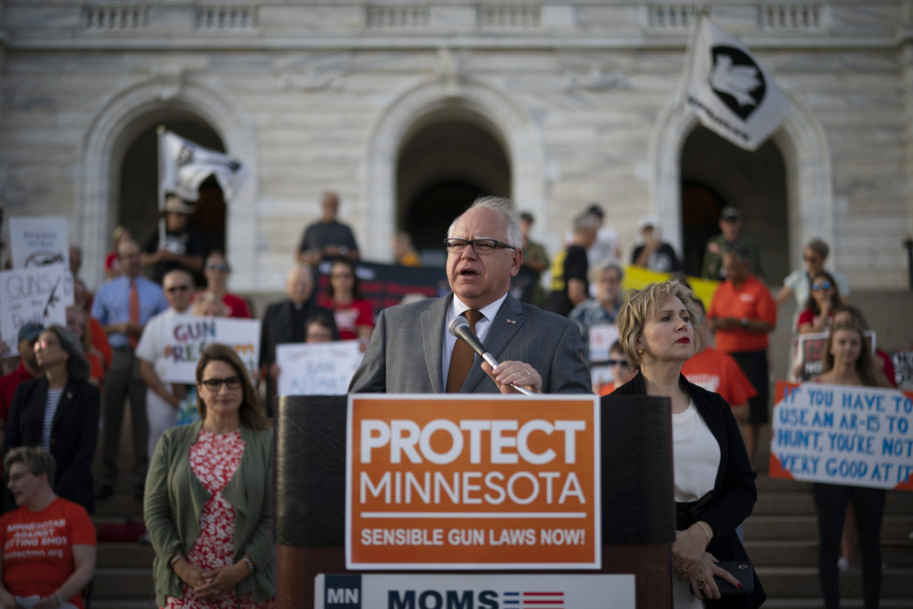 FILE - Gov. Tim Walz speaks before a crowd gathered for a rally on the steps of the state Capitol in St. Paul, Minn., Wednesday evening, Aug. 7, 2019. Lt. Gov. Peggy Flanagan, center left, and his wife Gwen Walz, center right, stand by him. (Jeff Wheeler/Star Tribune via AP, File)