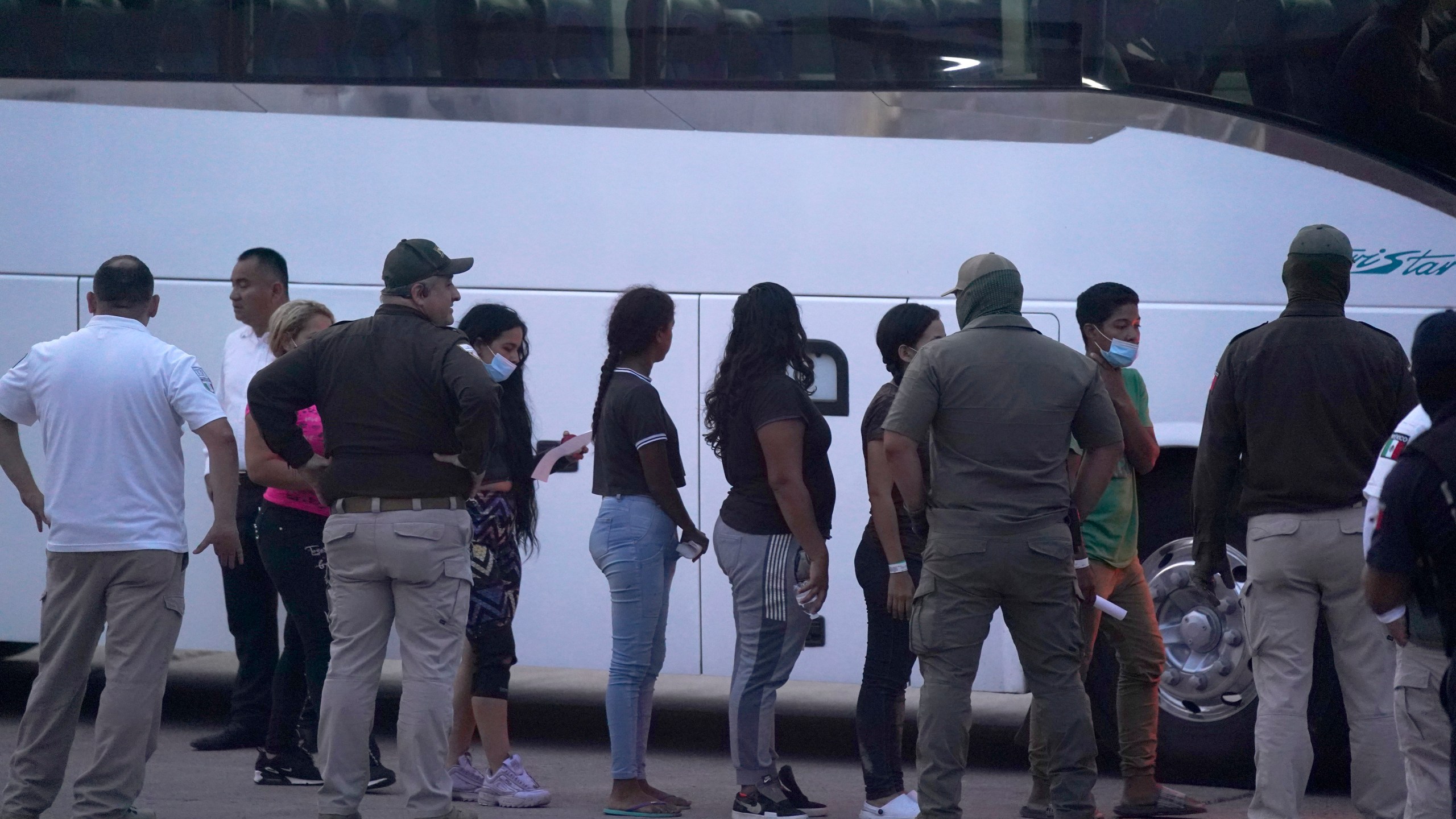 FILE - Migrants stand in line to board a bus after being deported from the U.S. side back to Matamoros, Mexico, May 11, 2023. (AP Photo/Fernando Llano, File)