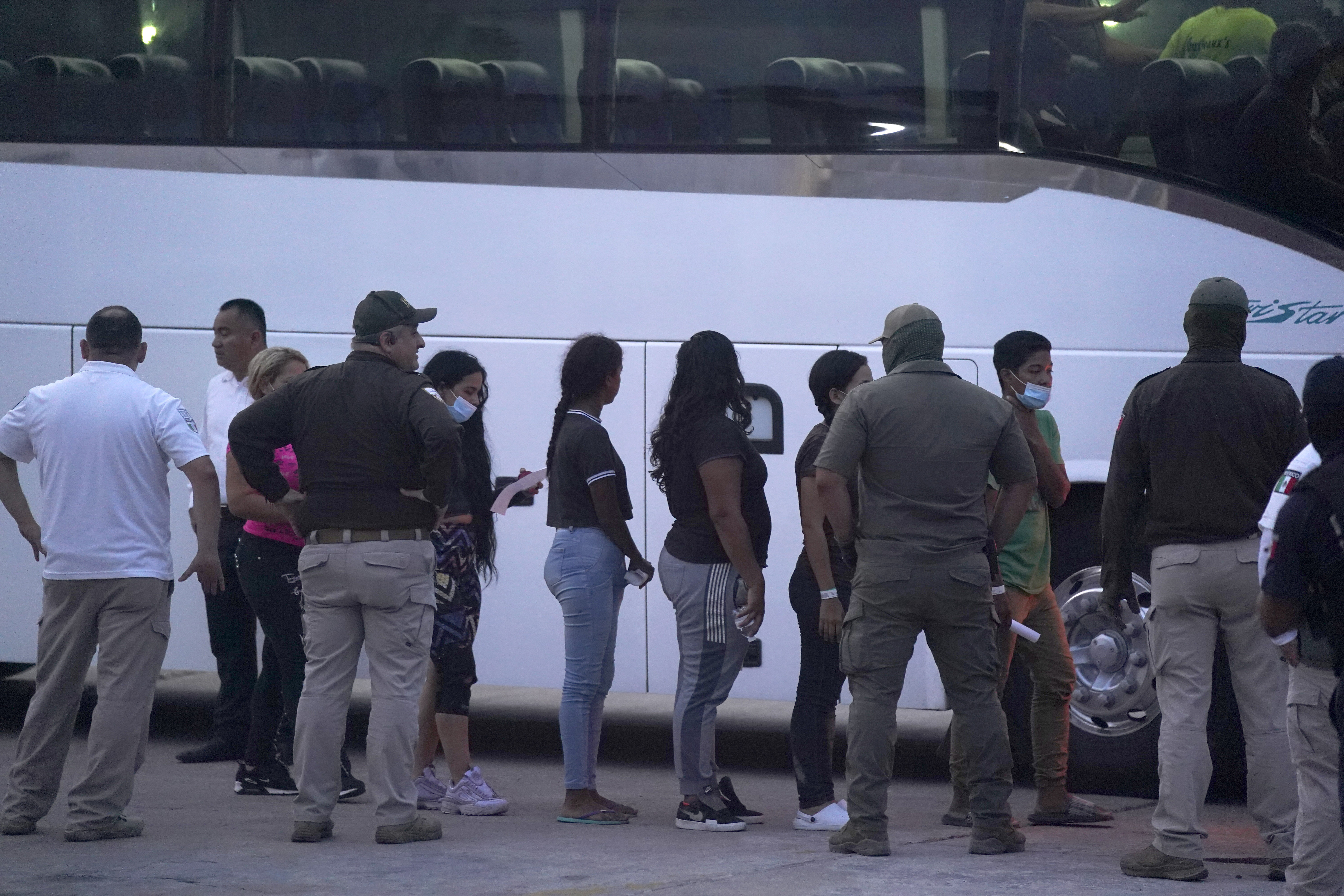 FILE - Migrants stand in line to board a bus after being deported from the U.S. side back to Matamoros, Mexico, May 11, 2023. (AP Photo/Fernando Llano, File)