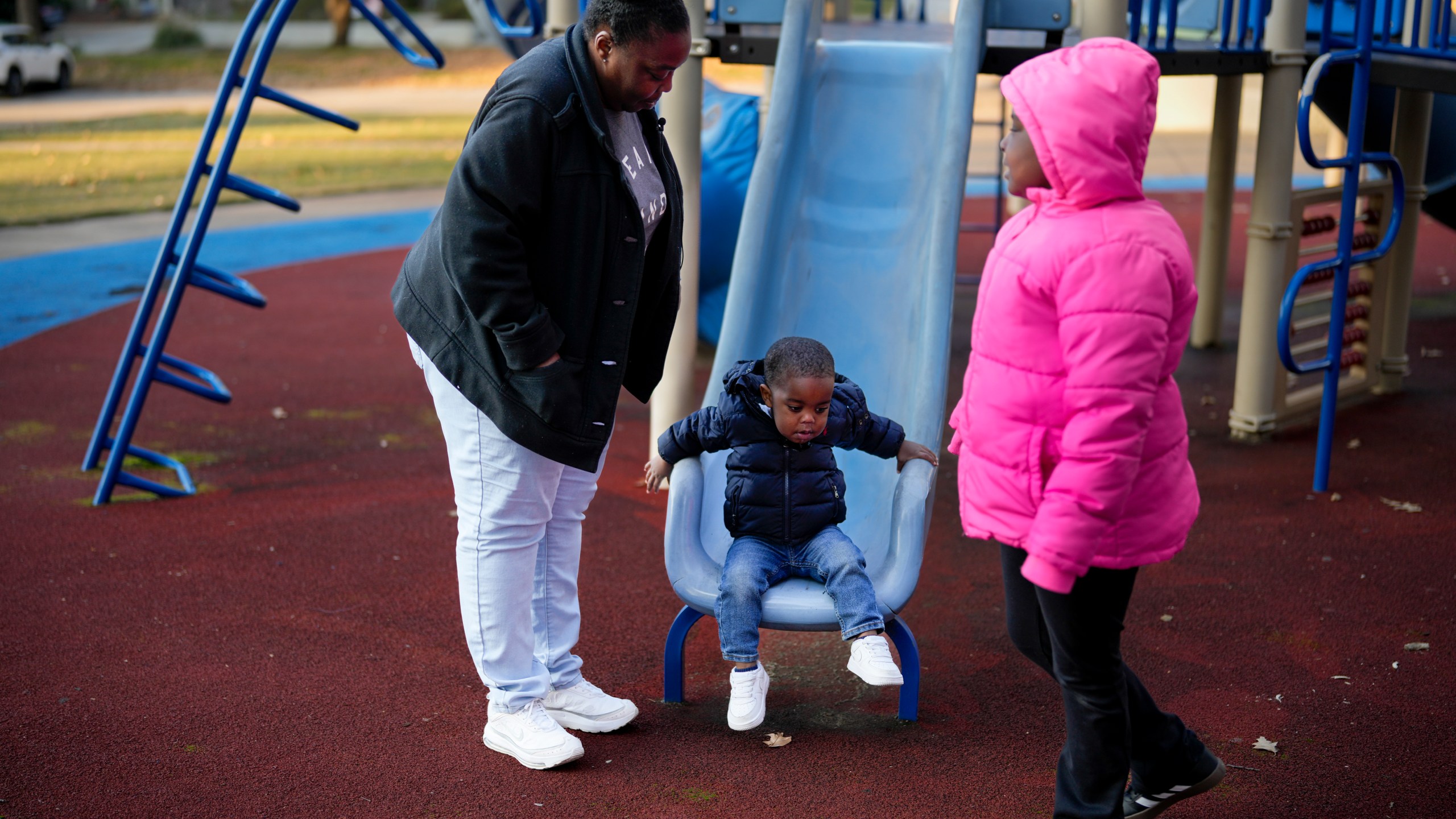 Anika Chillis spends time with her children, Makhi 2, and Myla 9, at a playground Monday, Dec. 2, 2024, in Memphis, Tenn. (AP Photo/George Walker IV)