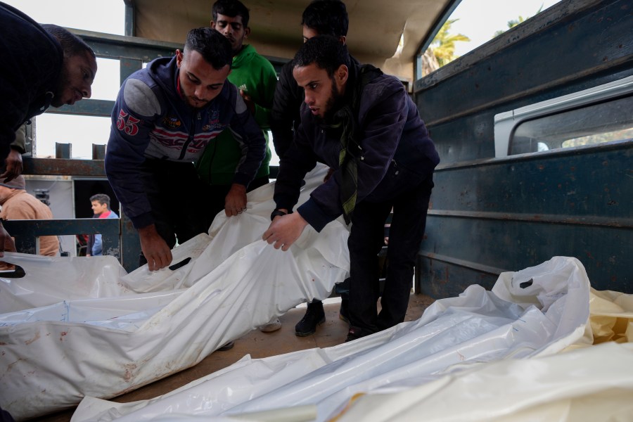 Palestinians carry white sacks containing the bodies of those killed in overnight Israeli airstrikes on the Maghazi refugee camp, at Al-Aqsa Hospital, in Deir al-Balah, central Gaza Strip, Saturday, Dec. 28, 2024. (AP Photo/Abdel Kareem Hana)