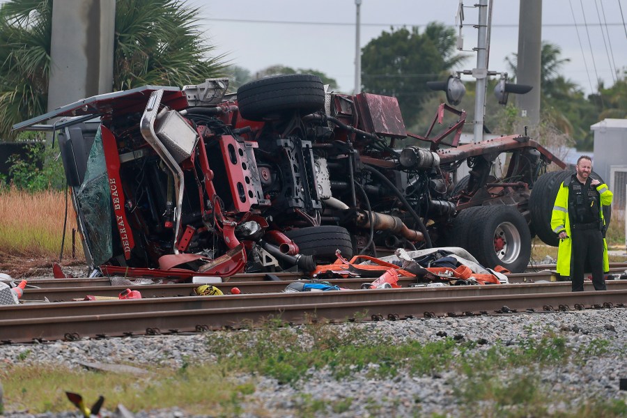 A damaged fire truck is on its side after colliding with a train in downtown Delray Beach, Fla., Saturday, Dec. 28, 2024. (Mike Stocker/South Florida Sun-Sentinel via AP)