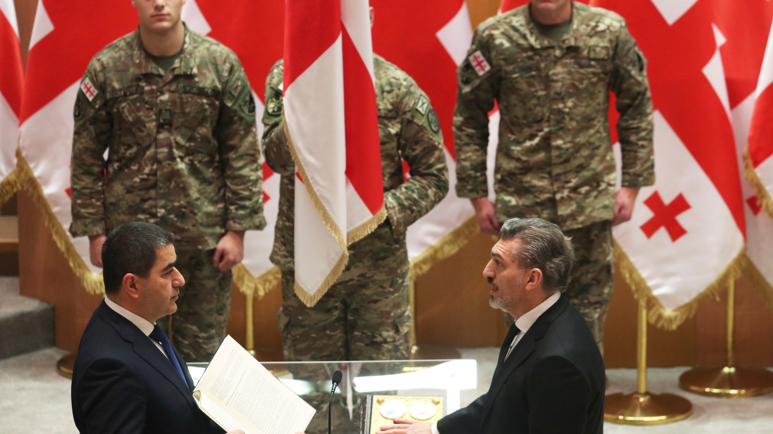 Georgian President-elect Mikheil Kavelashvili, right, takes the oath during his swearing-in ceremony at the Georgian parliament in Tbilisi, Georgia, Sunday, Dec. 29, 2024. (Irakli Gedenidze/Pool Photo via AP)