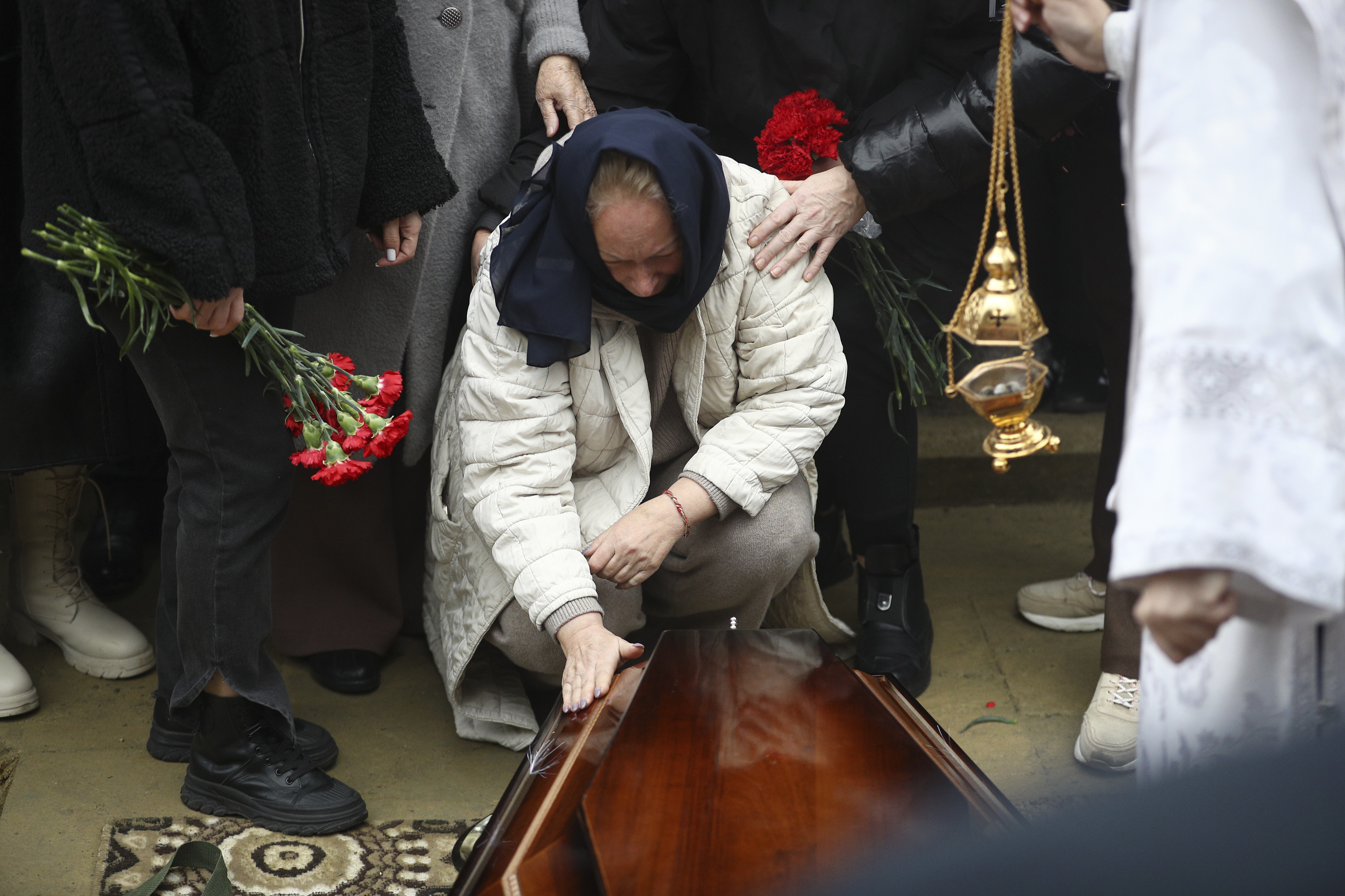 Yana Kshnyakina, widow of pilot in command Igor Kshnyakin mourns at the coffin during a funeral of crew members of the Azerbaijan Airlines Embraer 190 killed in a deadly plane crash in Kazakhstan this week, at the II Alley of Honor in Baku, Azerbaijan, Sunday, Dec. 29, 2024. (AP photo)