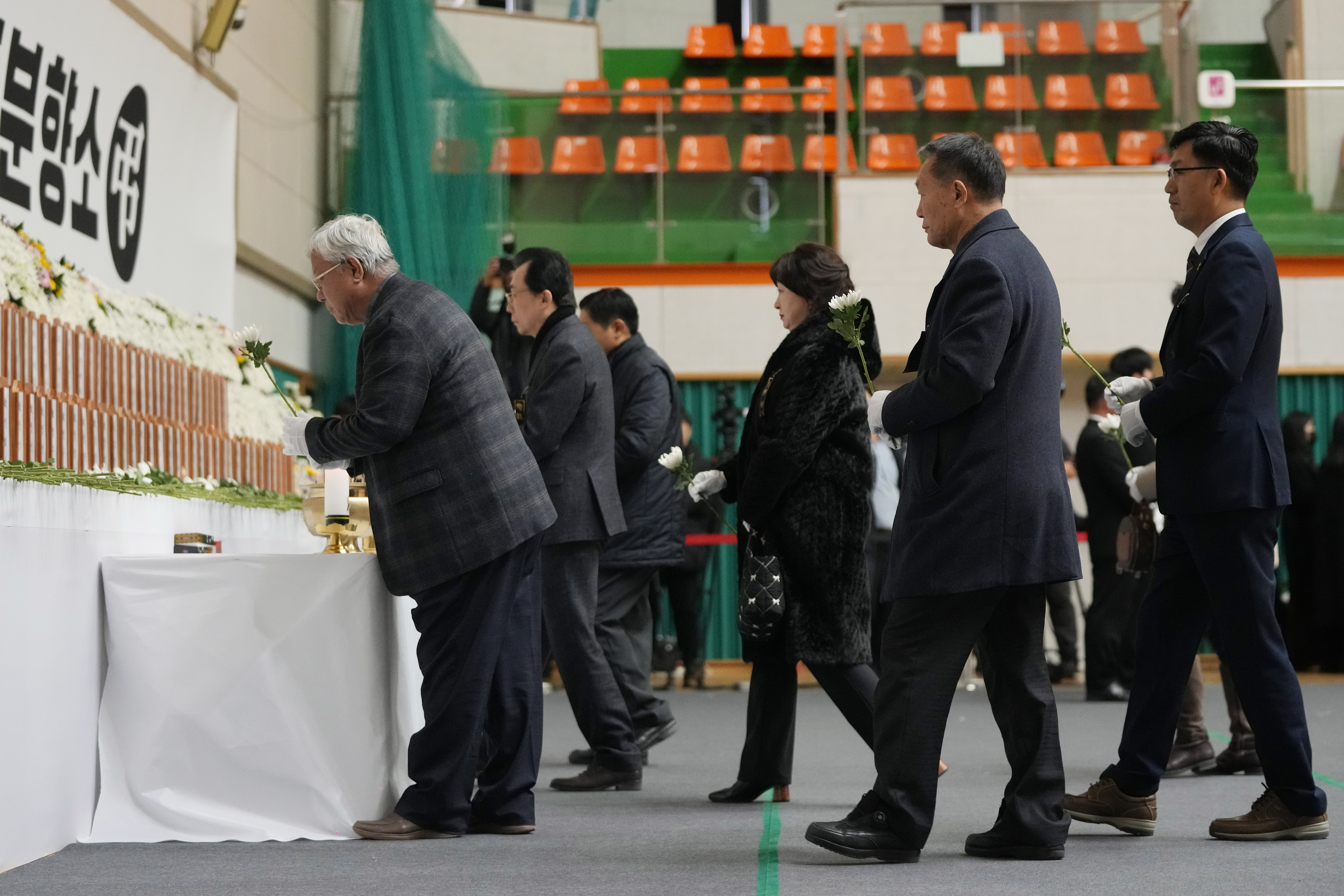 Mourners place flowers for the victims of a plane fire at a memorial altar at Muan sport park in Muan, South Korea, Monday, Dec. 30, 2024. (AP Photo/Ahn Young-joon)