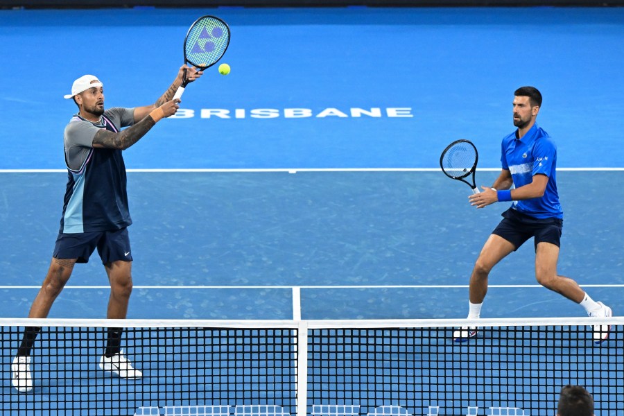 Australia's Nick Kyrgios, left, and Serbia's Novak Djokovic in action during their doubles match against Alexander Erler of Austria and Andreas Mies of Germany in the Brisbane International, at the Queensland Tennis Centre in Brisbane, Australia, Monday, Dec. 30, 2024. (Darren England/AAP Image via AP)