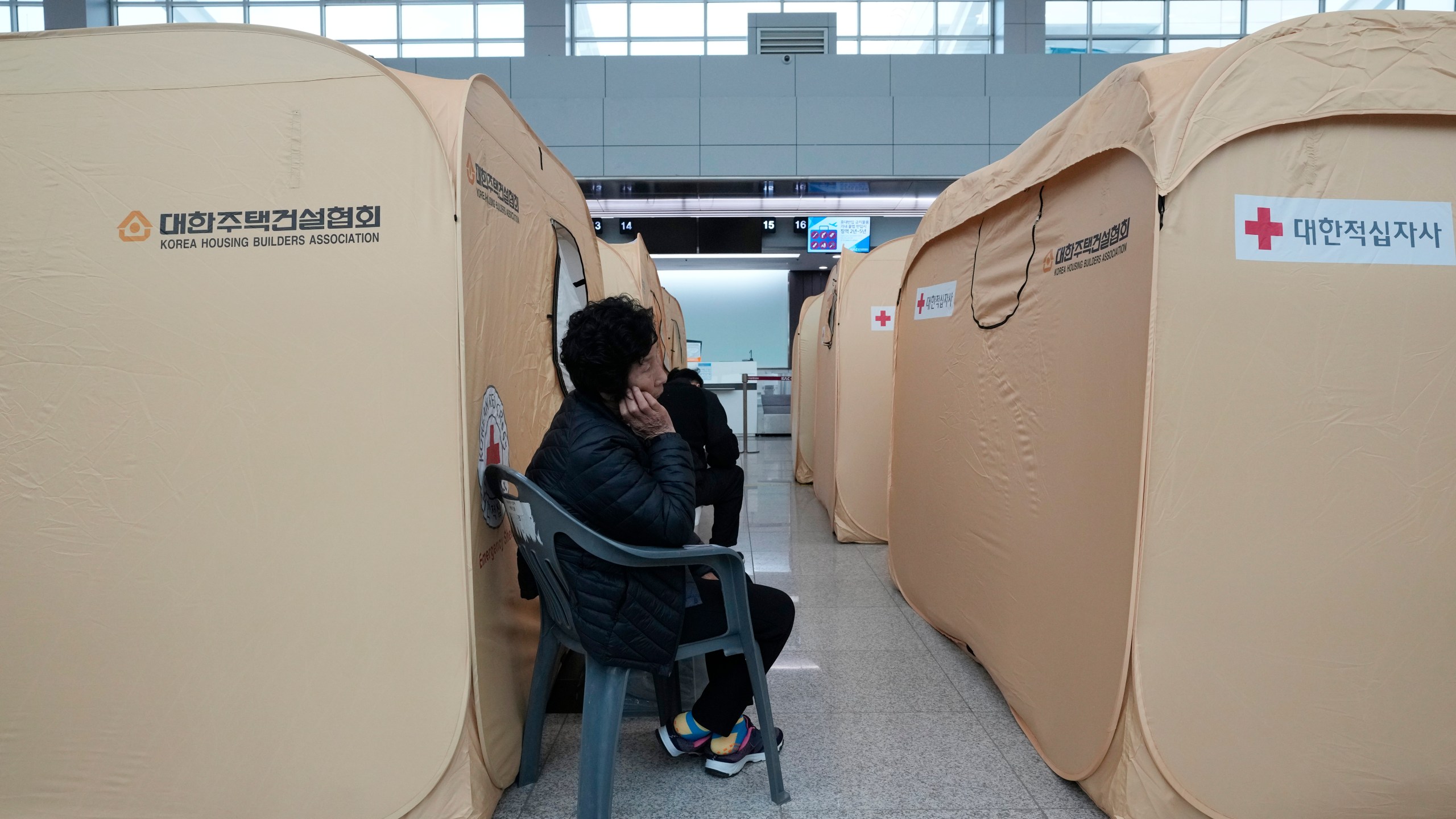 A relative of a passenger of a plane which burst into flames, reacts at a temporary shelter at Muan International Airport in Muan, South Korea, Monday, Dec. 30, 2024. (AP Photo/Ahn Young-joon)