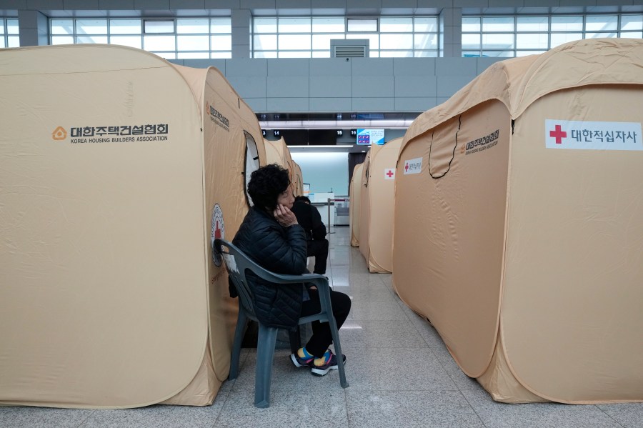 A relative of a passenger of a plane which burst into flames, reacts at a temporary shelter at Muan International Airport in Muan, South Korea, Monday, Dec. 30, 2024. (AP Photo/Ahn Young-joon)