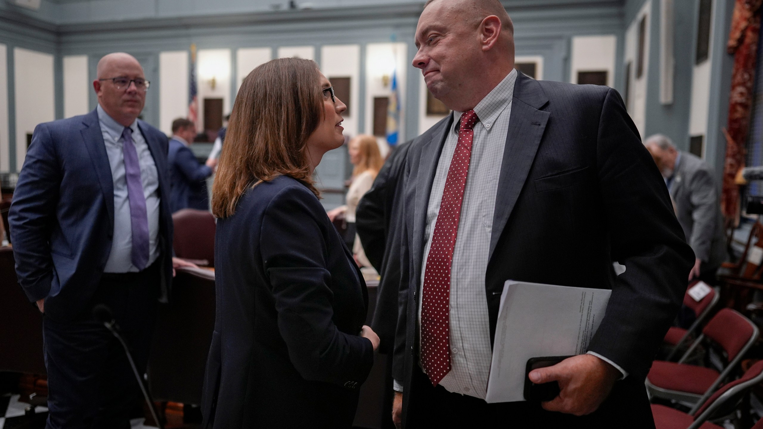 U.S.-Rep.-elect Sarah McBride, D-Del., center, talks with Delaware Senate Republican Minority Whip Brian Pettyjohn from the 19th district on the Senate floor on McBride's last day as a Delaware state senator at the Delaware Legislative Hall in Dover, Del., Monday, Dec. 16, 2024. (AP Photo/Carolyn Kaster)