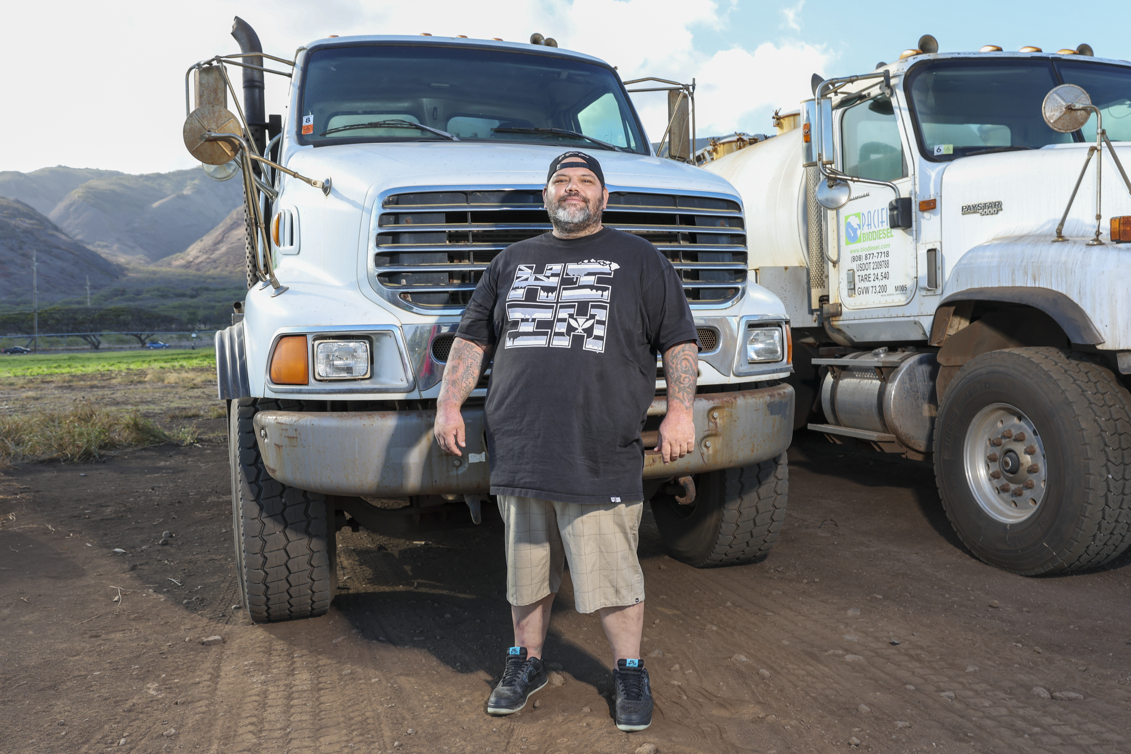 Joshua Kamalo, 43, stands by a truck he drives for work Wednesday, Dec. 18, 2024, in Maalaea, Hawaii. (AP Photo/Marco Garcia)