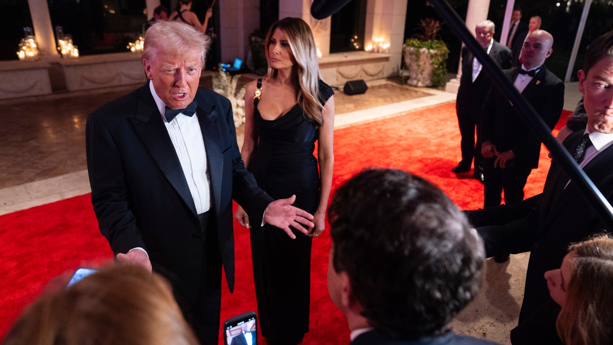 Melania Trump looks on as President-elect Donald Trump speaks to reporters before a New Year's Eve party at Mar-a-Lago, Tuesday, Dec. 31, 2024, in Palm Beach, Fla. (AP Photo/Evan Vucci)