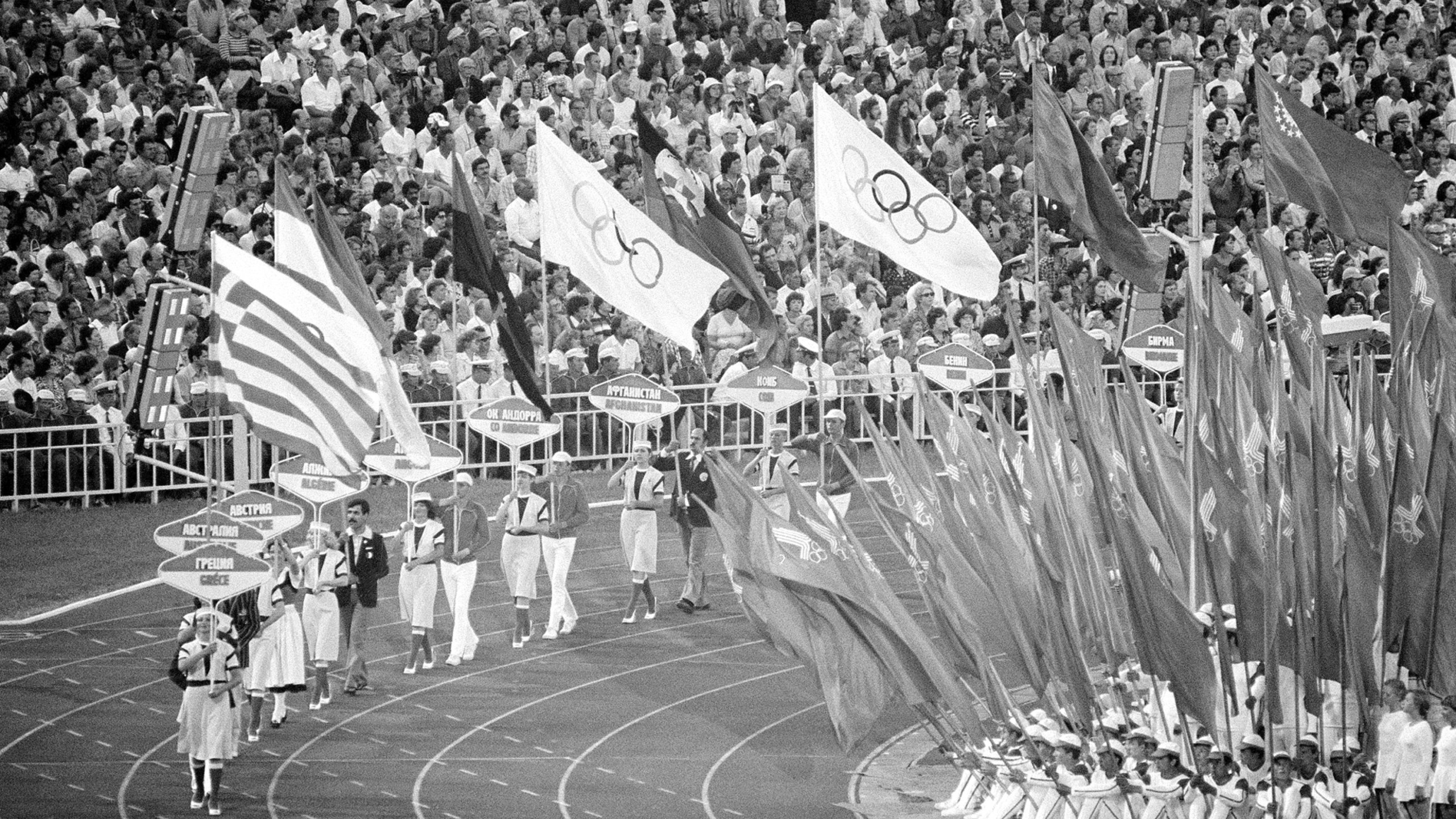 FILE - Flag and sign bearers march around Moscow's Lenin Stadium during closing ceremonies of the XXII Summer Olympic Games in Moscow, on Aug. 3, 1980. (AP Photo/File)