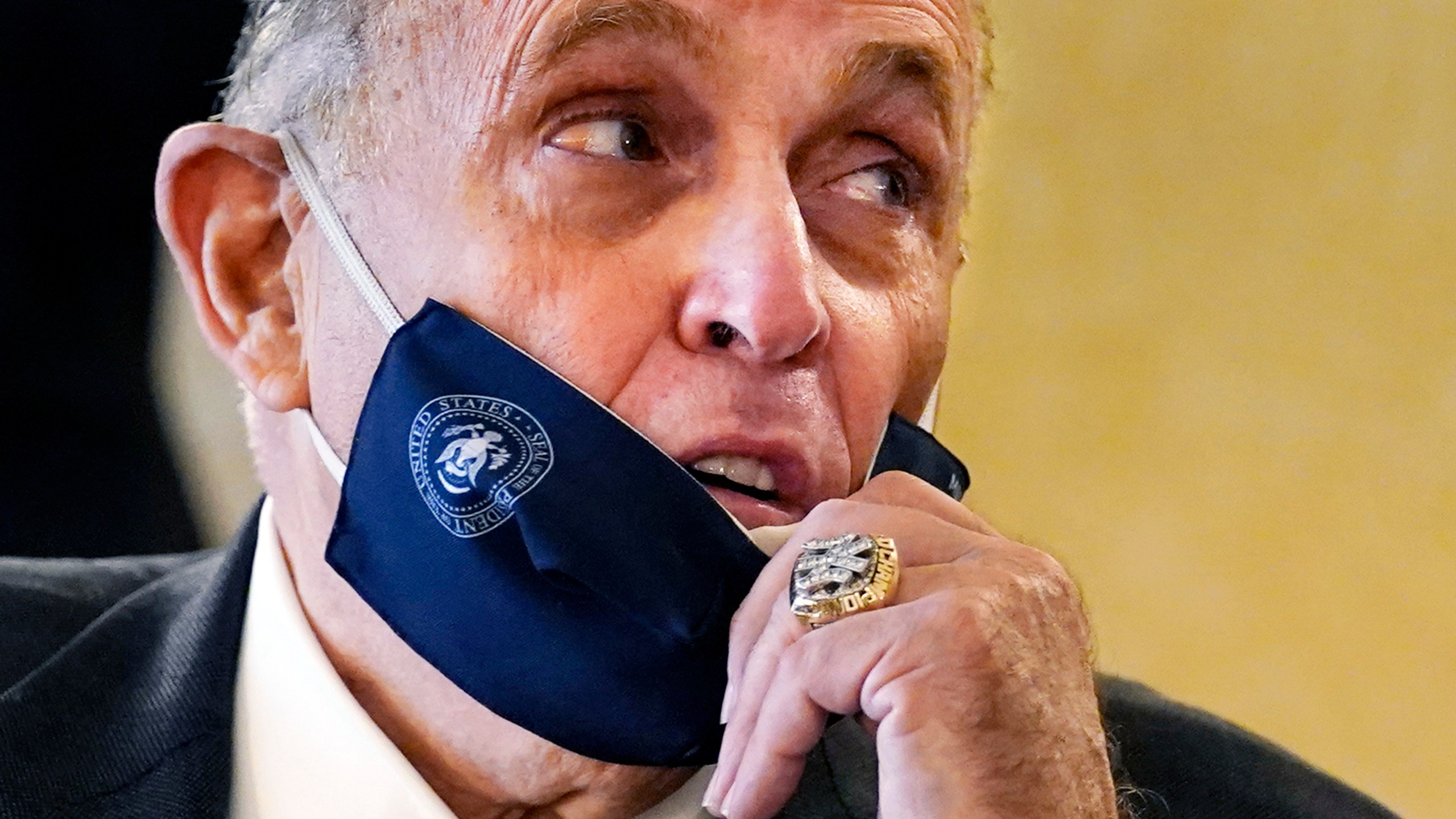 FILE — Former New York Mayor Rudy Giuliani, wearing a New York Yankees championship ring, pulls his face mask down to speak to an aide during a press conference at the Women's Republican Club, Sept. 16, 2020, in New York. (AP Photo/Kathy Willens, File)