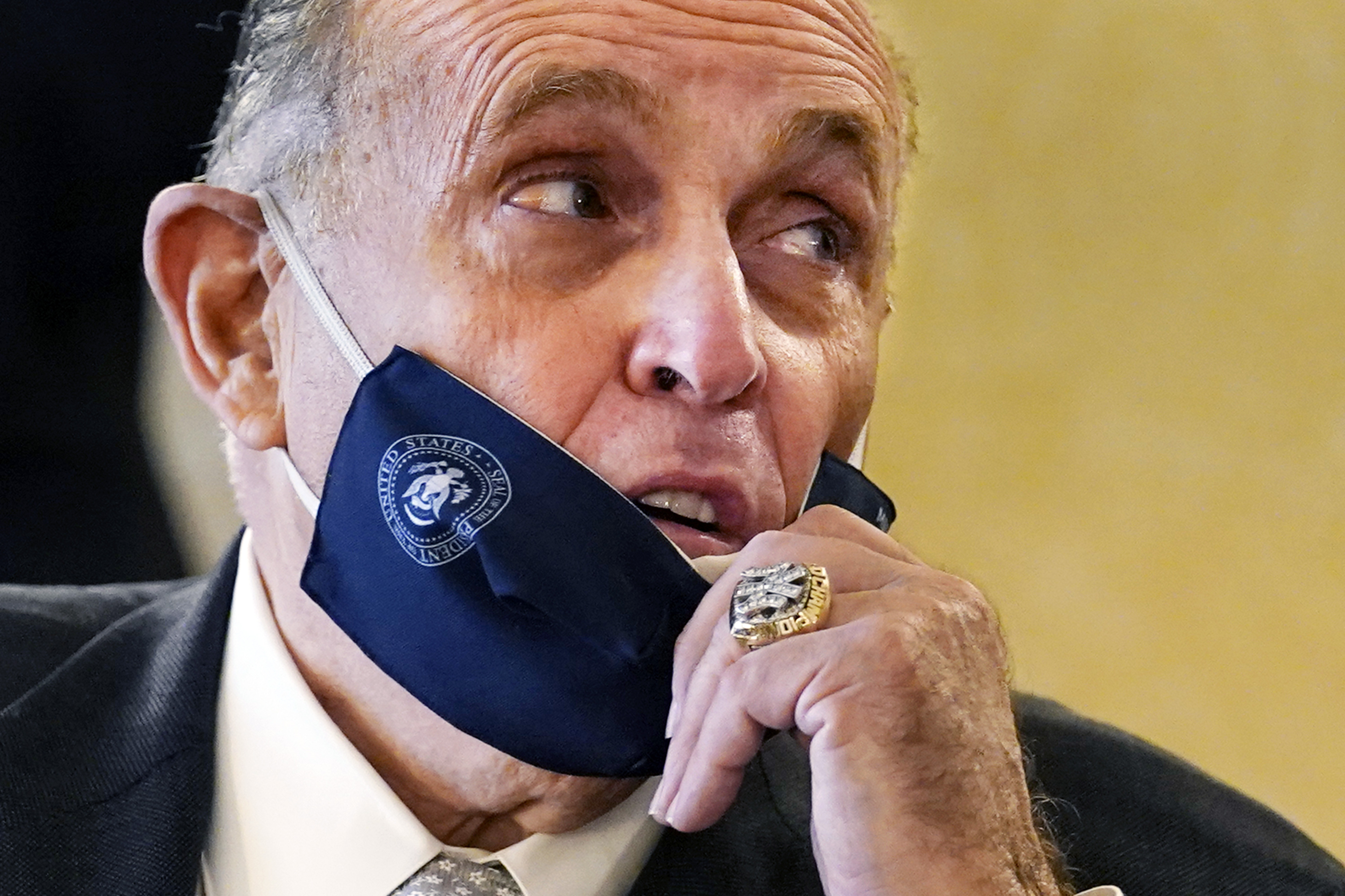 FILE — Former New York Mayor Rudy Giuliani, wearing a New York Yankees championship ring, pulls his face mask down to speak to an aide during a press conference at the Women's Republican Club, Sept. 16, 2020, in New York. (AP Photo/Kathy Willens, File)