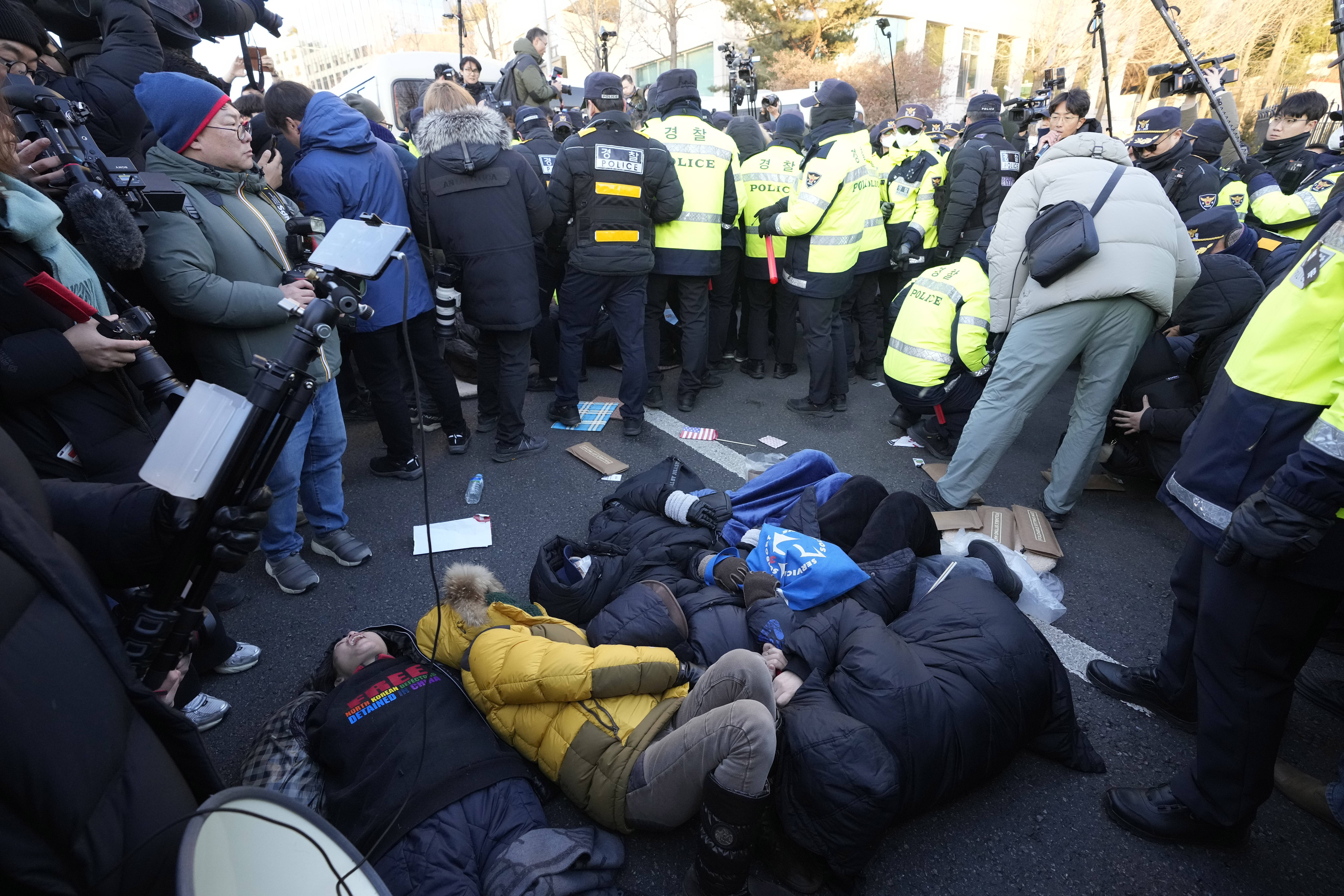 Supporters of impeached South Korean President Yoon Suk Yeol lie down on the ground as Yoon faces potential arrest after a court on Tuesday approved a warrant for his arrest, near the presidential residence in Seoul, South Korea, Thursday, Jan. 2, 2025. (AP Photo/Ahn Young-joon)