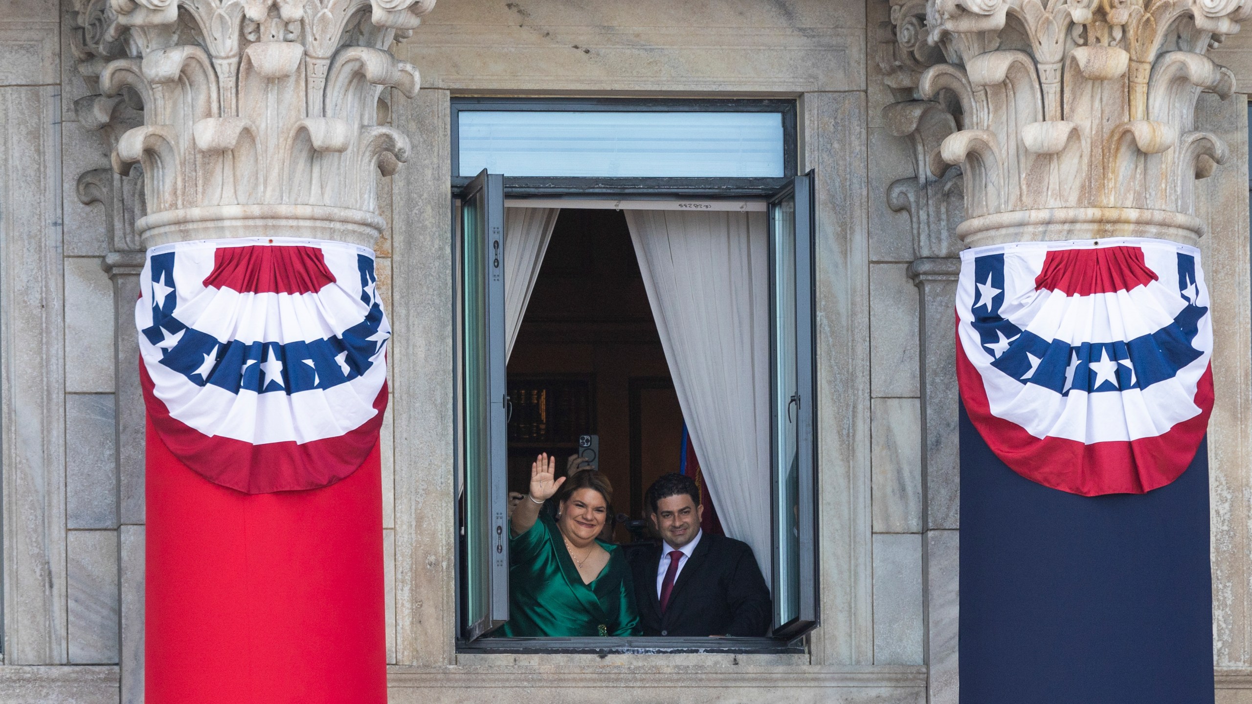 Jenniffer Gonzalez Colon waves next to her husband Jose Yovin Vargas, after her swearing-in ceremony as governor at the Capitol in San Juan, Puerto Rico, Thursday, Jan. 2, 2025. (AP Photo/Alejandro Granadillo)