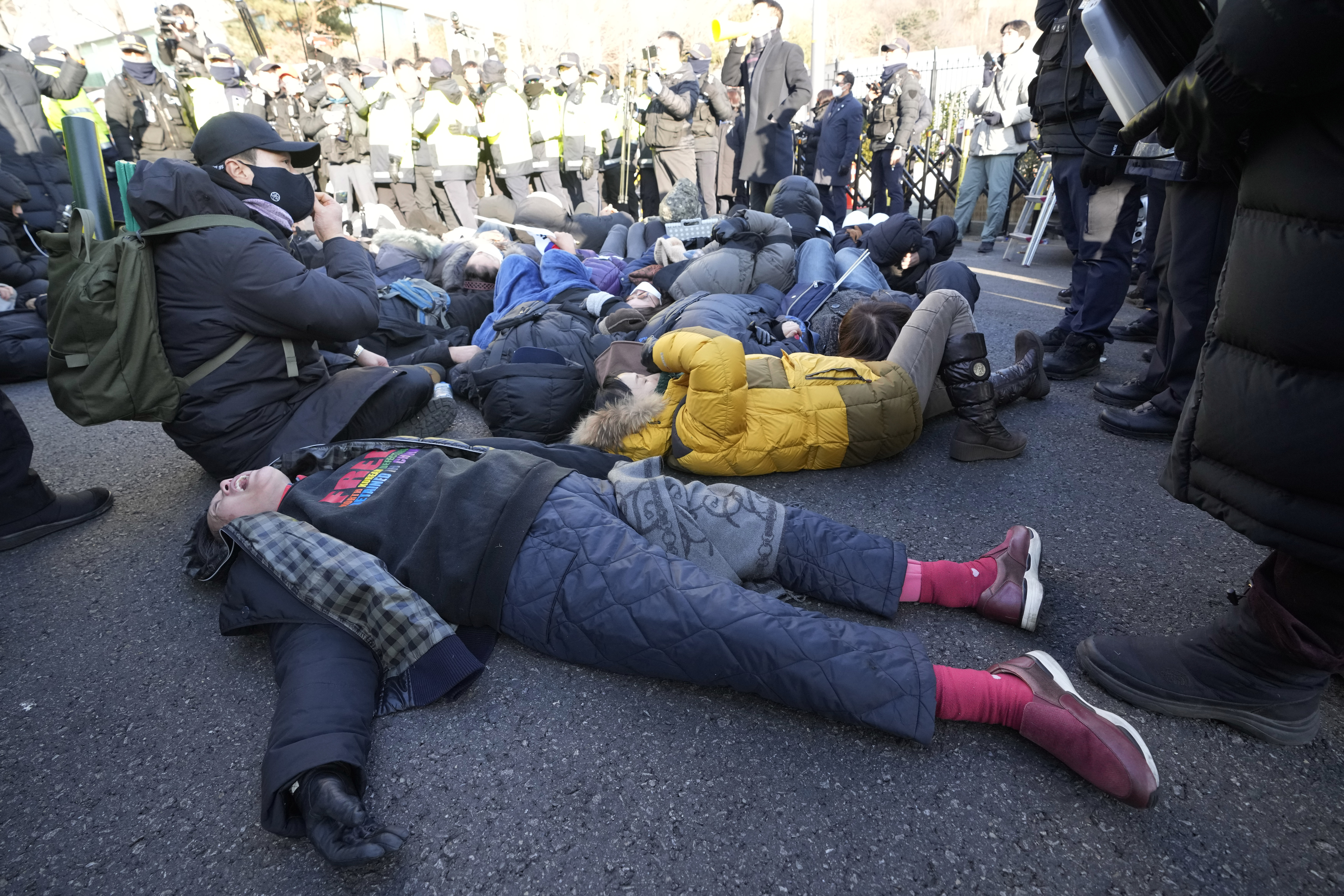 Supporters of impeached South Korean President Yoon Suk Yeol lie down on the ground as Yoon faces potential arrest after a court on Tuesday approved a warrant for his arrest, near the presidential residence in Seoul, South Korea, Thursday, Jan. 2, 2025. (AP Photo/Ahn Young-joon)