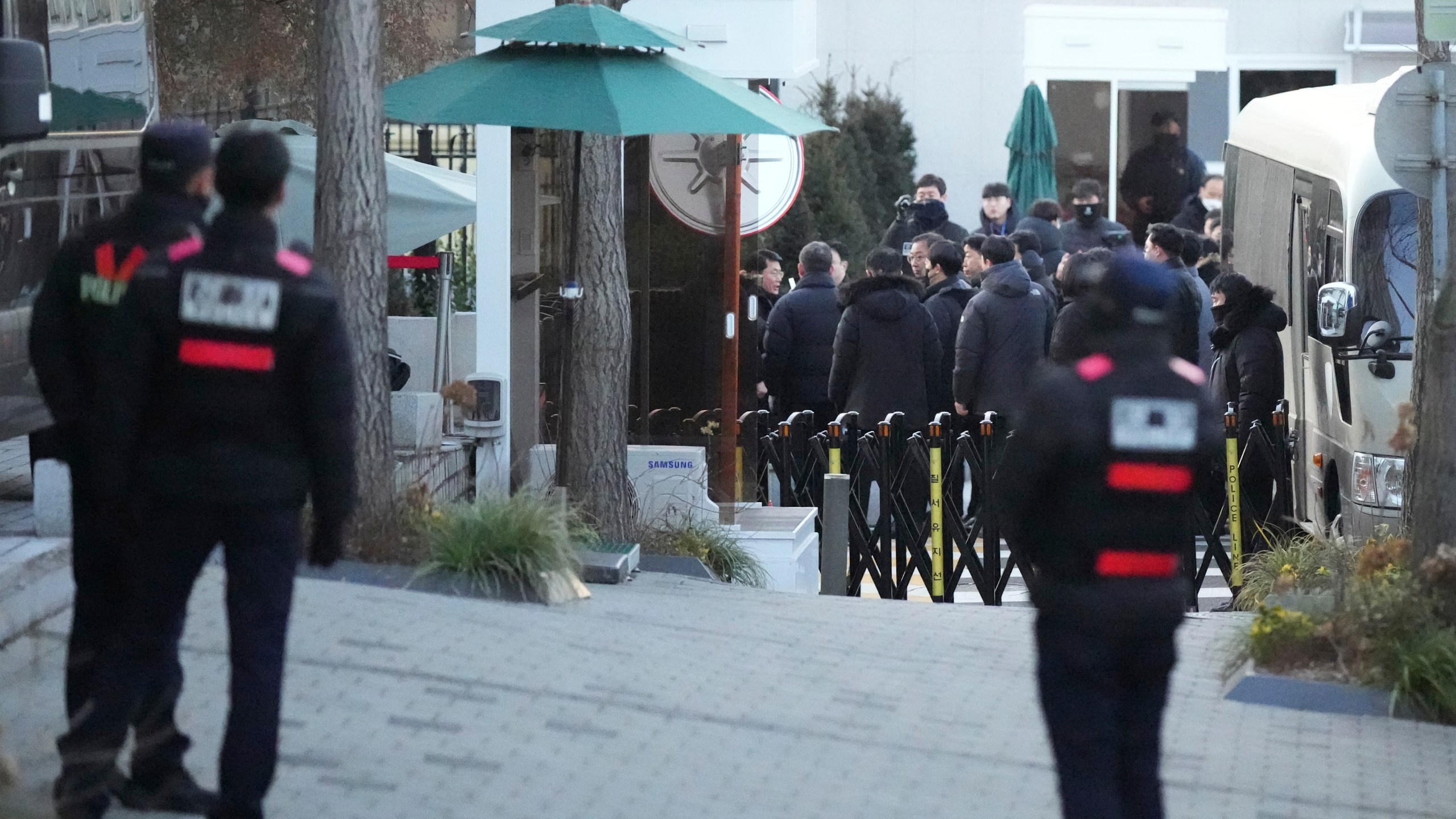 Investigators from the Corruption Investigation Office for High-ranking Officials arrive at the gate of the presidential residence as supporters of impeached South Korean President Yoon Suk Yeol stage a rally to oppose a court having issued a warrant to detain Yoon, in Seoul, South Korea, Friday, Jan. 3, 2025. (AP Photo/Lee Jin-man)