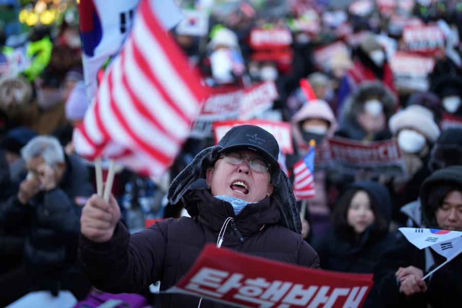 Supporters of impeached South Korean President Yoon Suk Yeol stage a rally to oppose a court having issued a warrant to detain Yoon, near the presidential residence in Seoul, South Korea, Friday, Jan. 3, 2025. The letters read, "Oppose Impeachment." (AP Photo/Lee Jin-man)