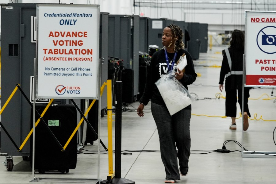 FILE - An election worker walks near voting machines at the Fulton County Election Hub and Operation Center, Nov. 5, 2024, in Atlanta. (AP Photo/John Bazemore, File)