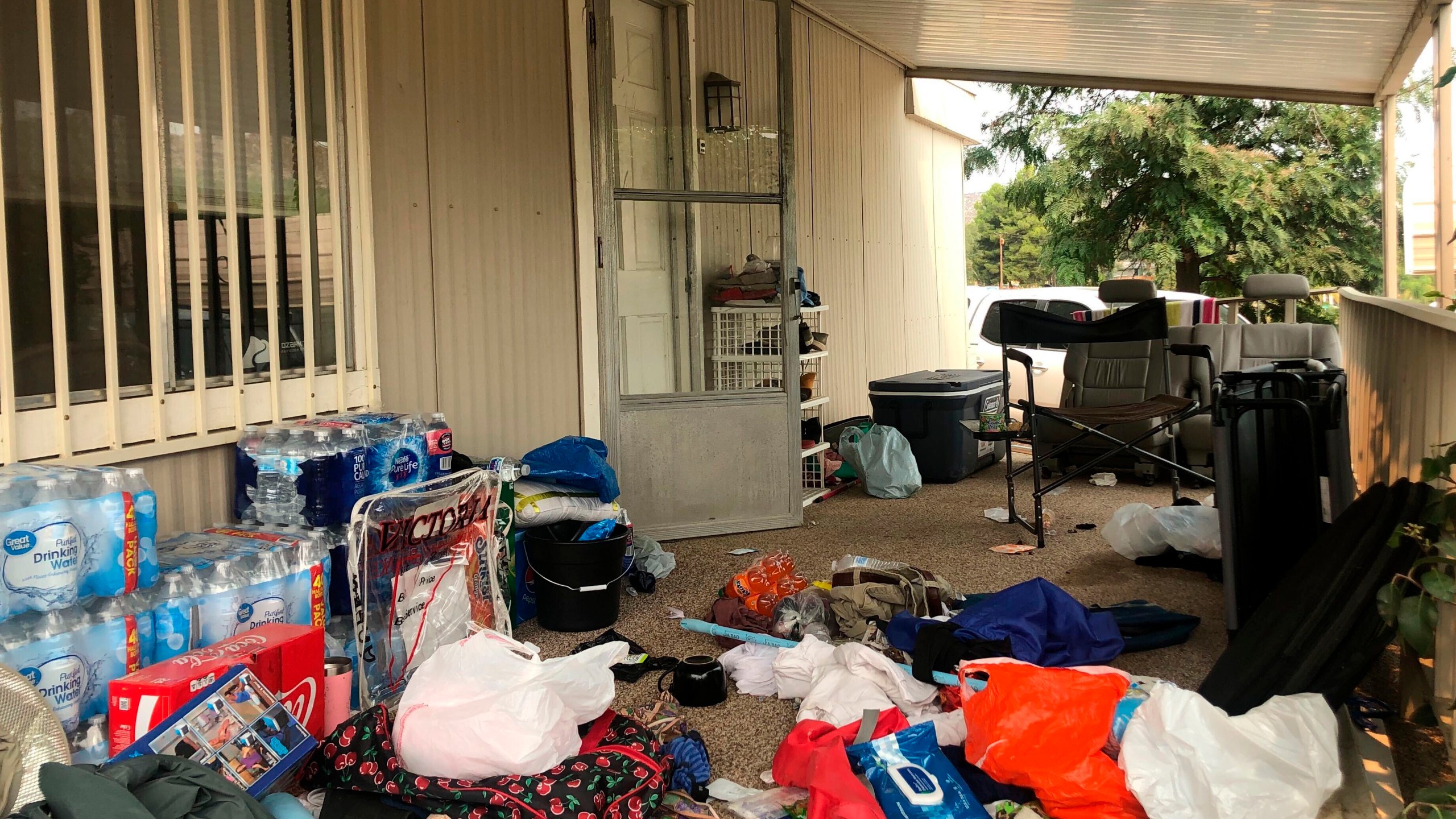 FILE - Cases of bottled water are seen with other items left on the porch of a house where killings occurred related to a Marijuana growing operation in Aguanga ,Calif., Tuesday, Sept. 8, 2020. (AP Photo/Elliot Spagat, File)