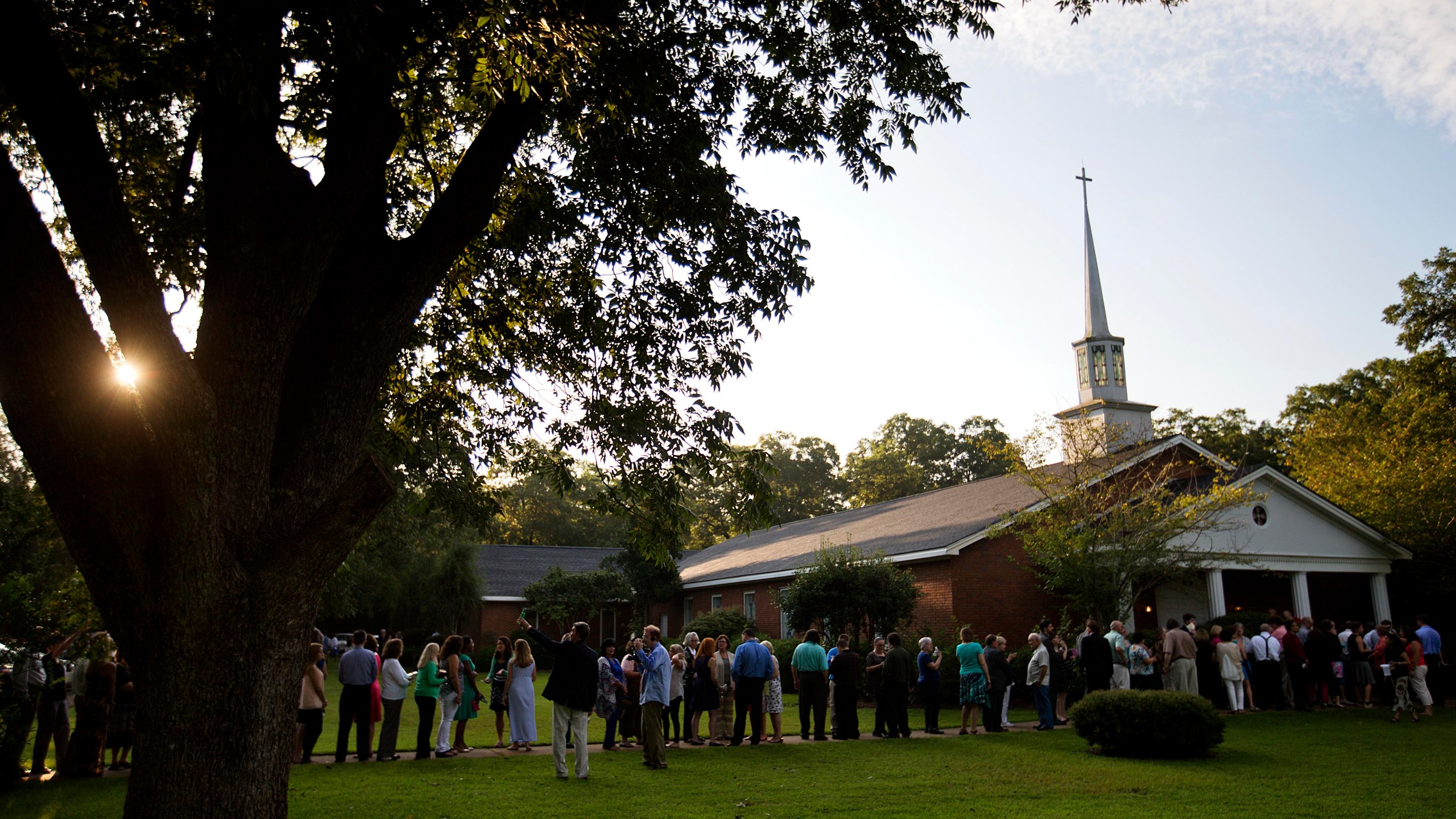 FILE - People wait in line outside Maranatha Baptist Church in Plains, Ga., to get into a Sunday school class taught by former U.S. President Jimmy Carter on Aug. 23, 2015. It was Carter's first lesson since announcing plans for intravenous drug doses and radiation to treat melanoma found in his brain after surgery to remove a tumor from his liver. (AP Photo/David Goldman, File)