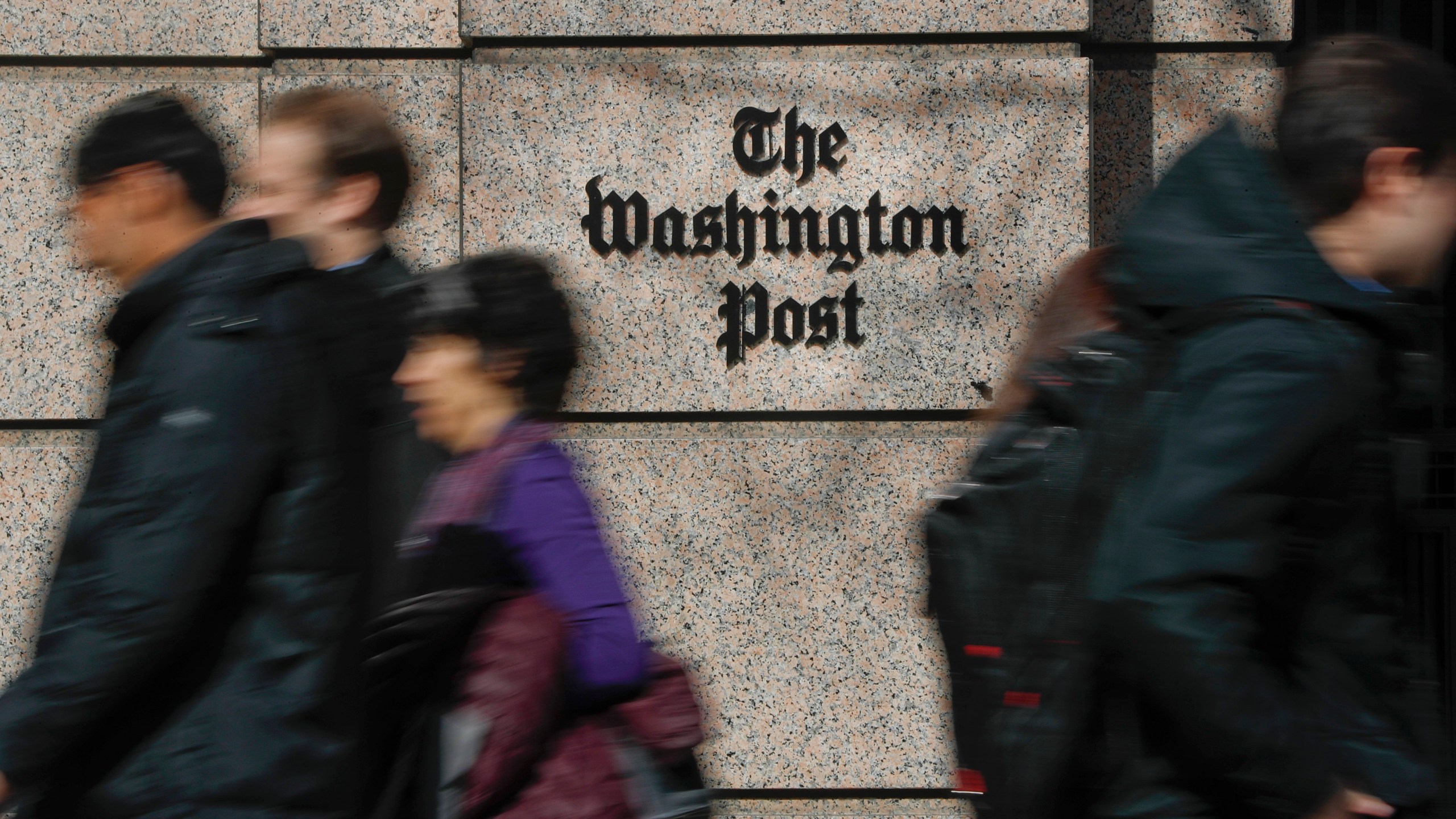 FILE - People walk by the One Franklin Square Building, home of The Washington Post newspaper, in downtown Washington, Feb. 21, 2019. (AP Photo/Pablo Martinez Monsivais, File)