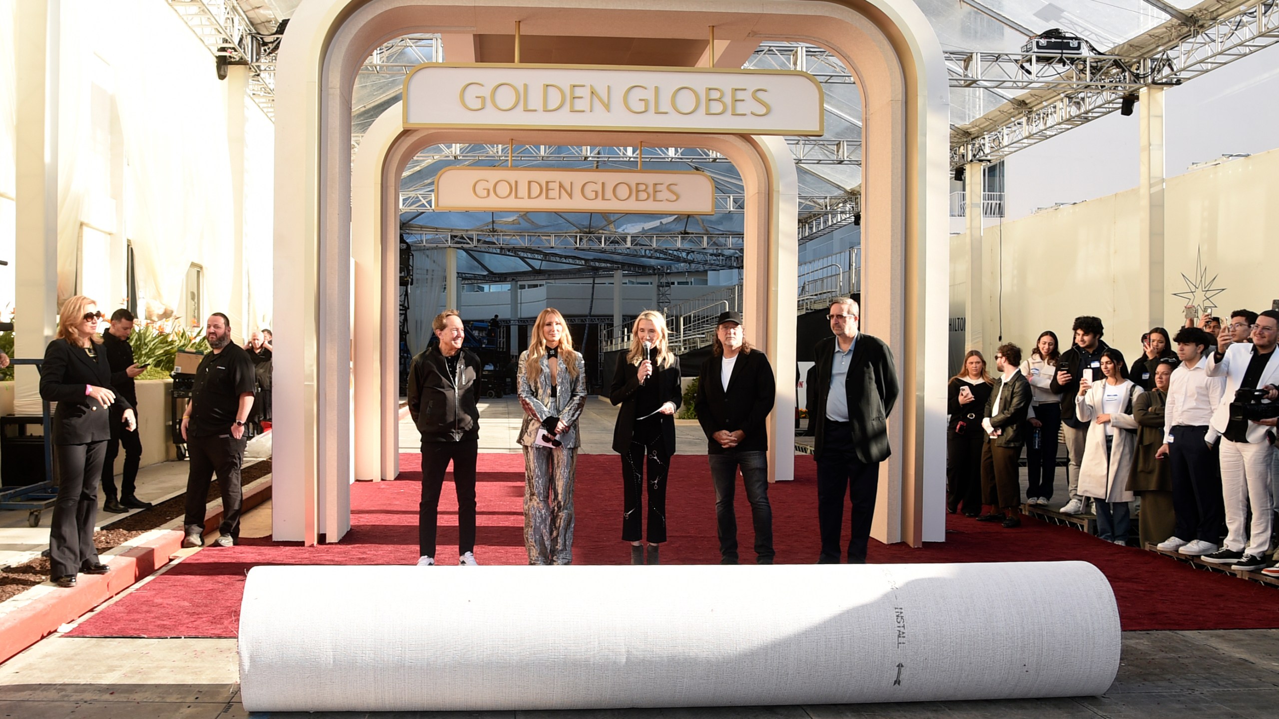 Barry Adelman, from left, Nikki Glaser, Helen Hoehne, Glenn Weiss, and Ricky Kirshner roll out the red carpet during the 82nd Golden Globes press preview on Thursday, Jan. 2, 2025, at the Beverly Hilton in Beverly Hills, Calif. (Photo by Richard Shotwell/Invision/AP)