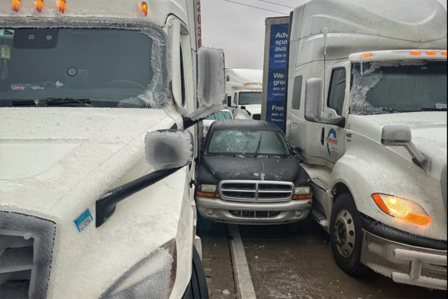 In a photo released by the Kansas Highway Patrol, a car is wedged between two trucks during icy weather Saturday, Jan. 4, 2024, in Salina, Kansas. (Kansas Highway Patrol via AP)