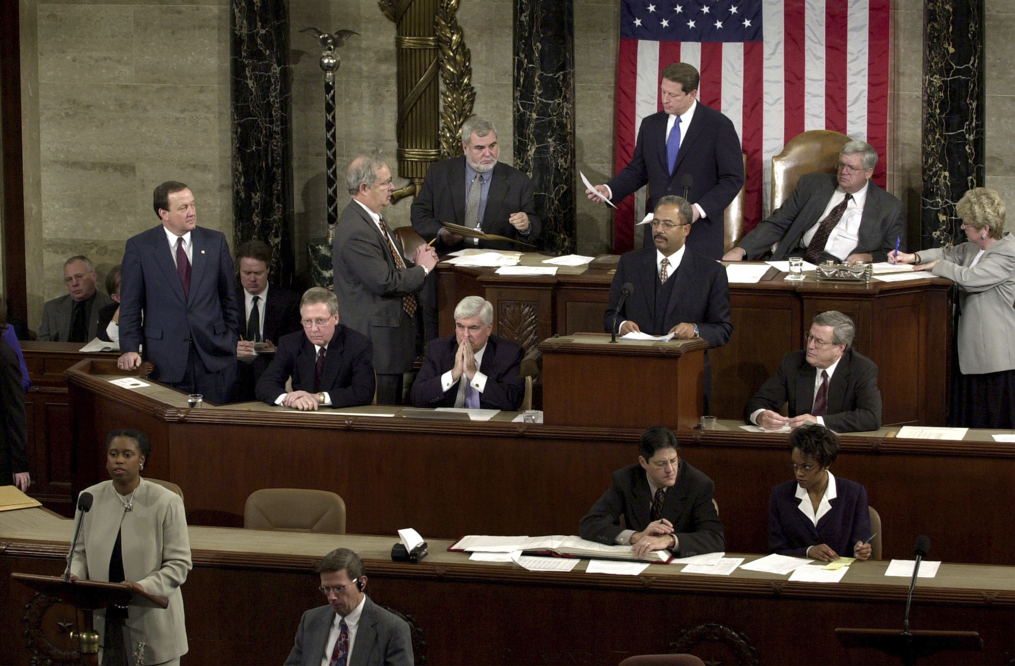 FILE - Rep. Cynthia McKinney, D-Ga., lower left, objects to Florida's electoral vote count results, as Vice President Al Gore, standing, top center, and House Speaker Dennis Hastert, R-Ill., seated, top right, listen on the floor of the U.S. House of Representatives, in Washington, Jan. 6, 2001. Other members present, seated at left in middle row are: Sen. Mitch McConnell, R-Ky., Chris Dodd, D-Ct, hand over mouth., Chaka Fattah, D-Pa., standing at podium and Rep. William Thomas, R-Calif. Others not identified. (AP Photo/Kenneth Lambert, File)