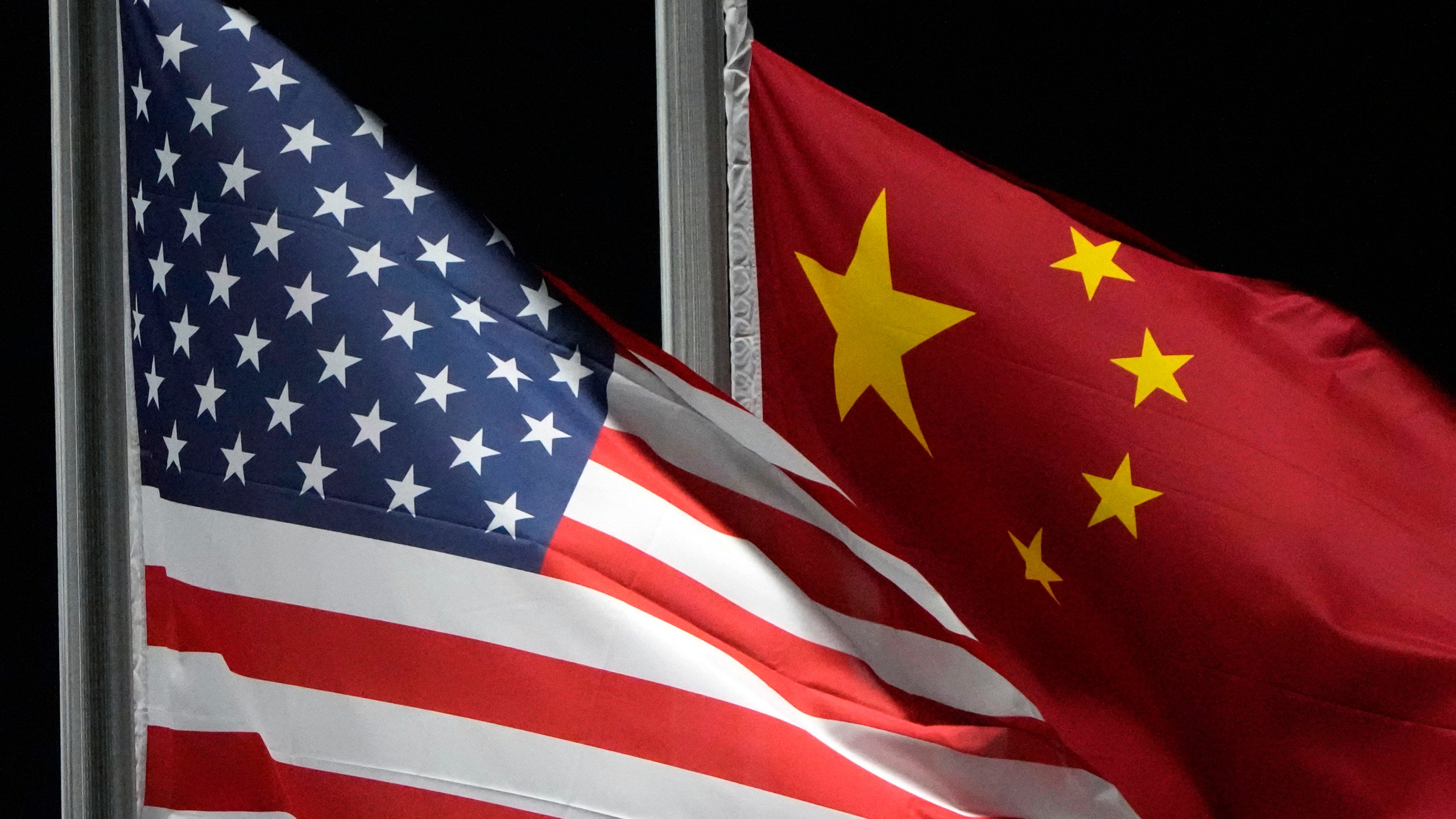 FILE - The American and Chinese flags wave at Genting Snow Park ahead of the 2022 Winter Olympics, Feb. 2, 2022, in Zhangjiakou, China. (AP Photo/Kiichiro Sato, File)