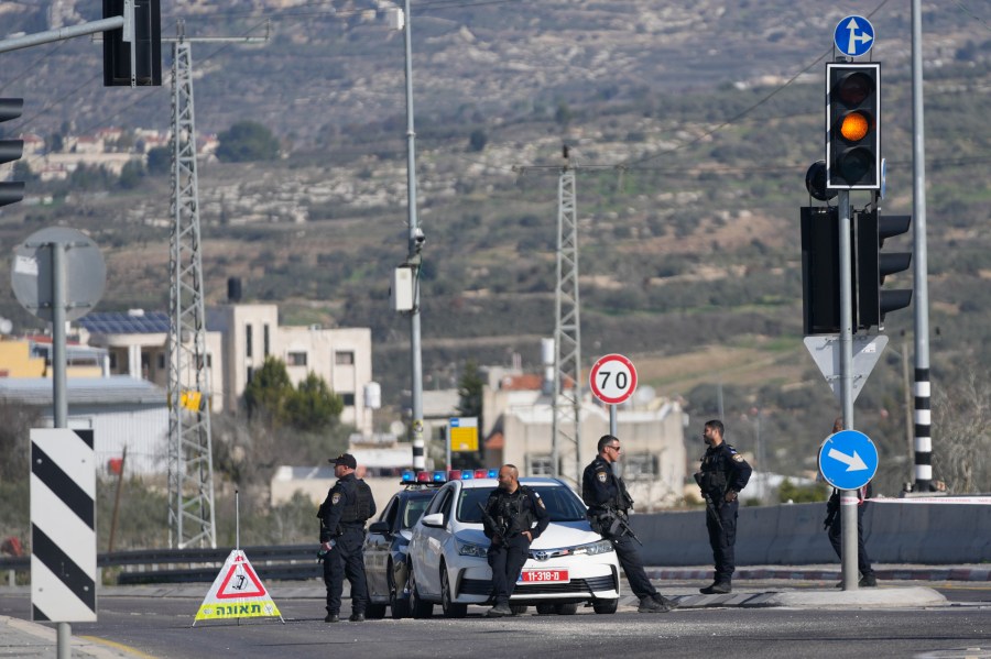 Israeli policemen block a main road after gunmen opened fire on cars and a bus carrying Israelis in the occupied West Bank, killing at least three people, near the Palestinian village of Al-Funduq, Monday, Jan. 6, 2025. (AP Photo/Nasser Nasser)