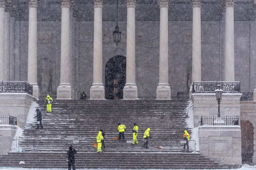 Workers clear steps at the Capitol as snow falls ahead of a joint session of Congress to certify the votes from the Electoral College in the presidential election, in Washington, Monday, Jan. 6, 2025. (AP Photo/J. Scott Applewhite)