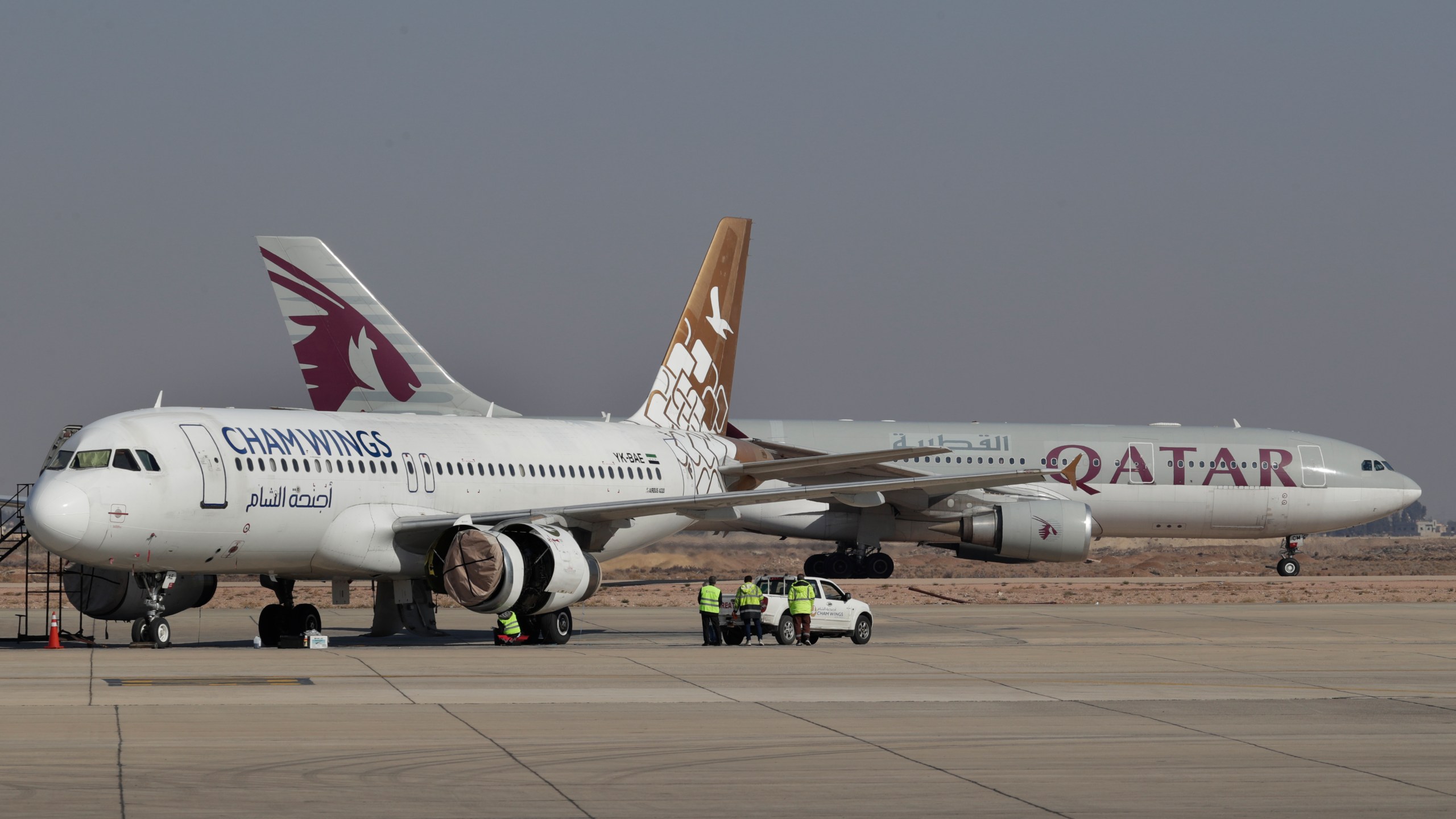 Qatar Airways plane, background, a first international commercial flight since the fall of former Syrian President Bashar Assad, lands at Damascus international airport arriving from Qatar, in Damascus, Syria, Tuesday, Jan. 7, 2025. (AP Photo/Omar Sanadiki)