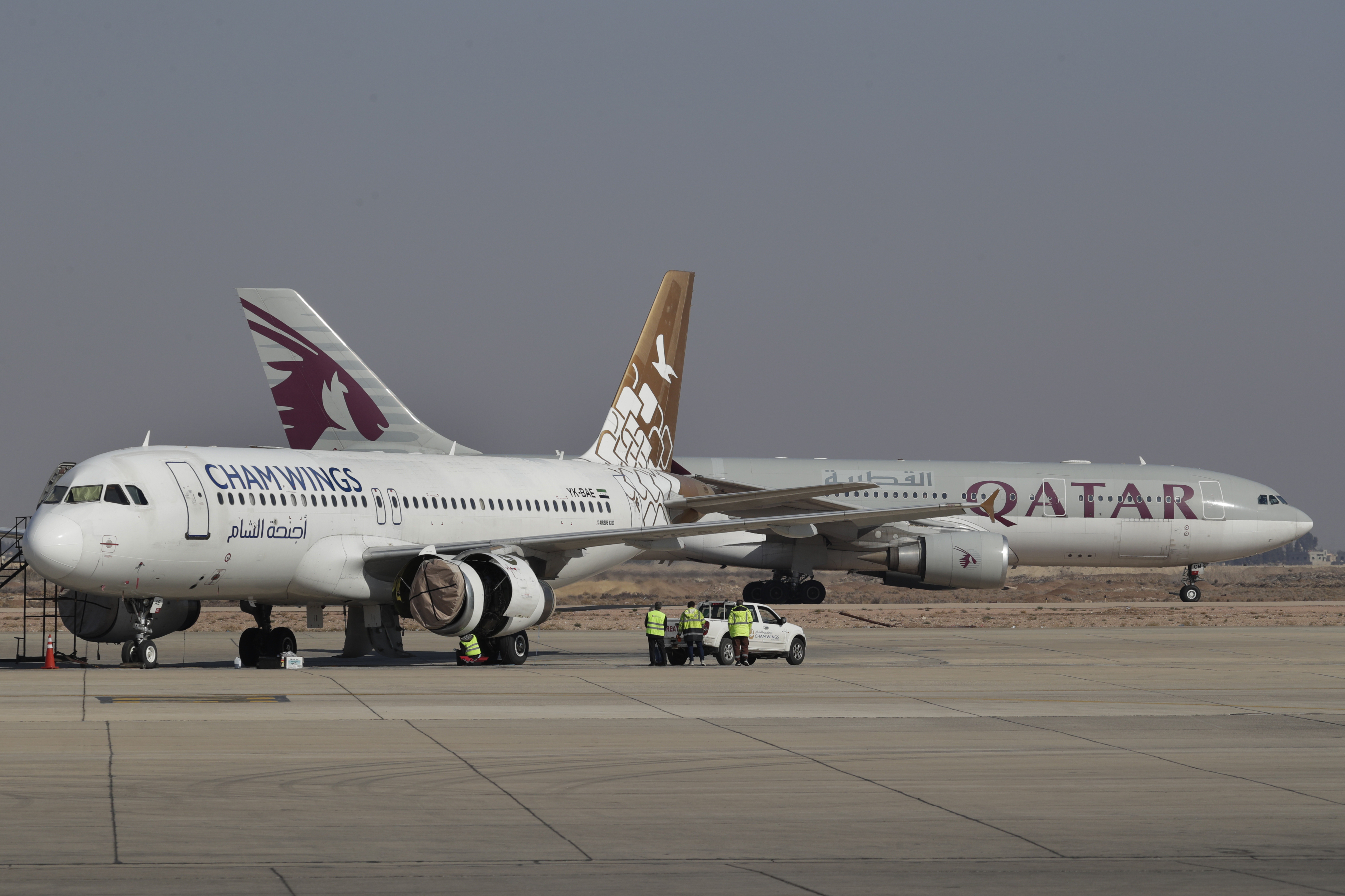 Qatar Airways plane, background, a first international commercial flight since the fall of former Syrian President Bashar Assad, lands at Damascus international airport arriving from Qatar, in Damascus, Syria, Tuesday, Jan. 7, 2025. (AP Photo/Omar Sanadiki)