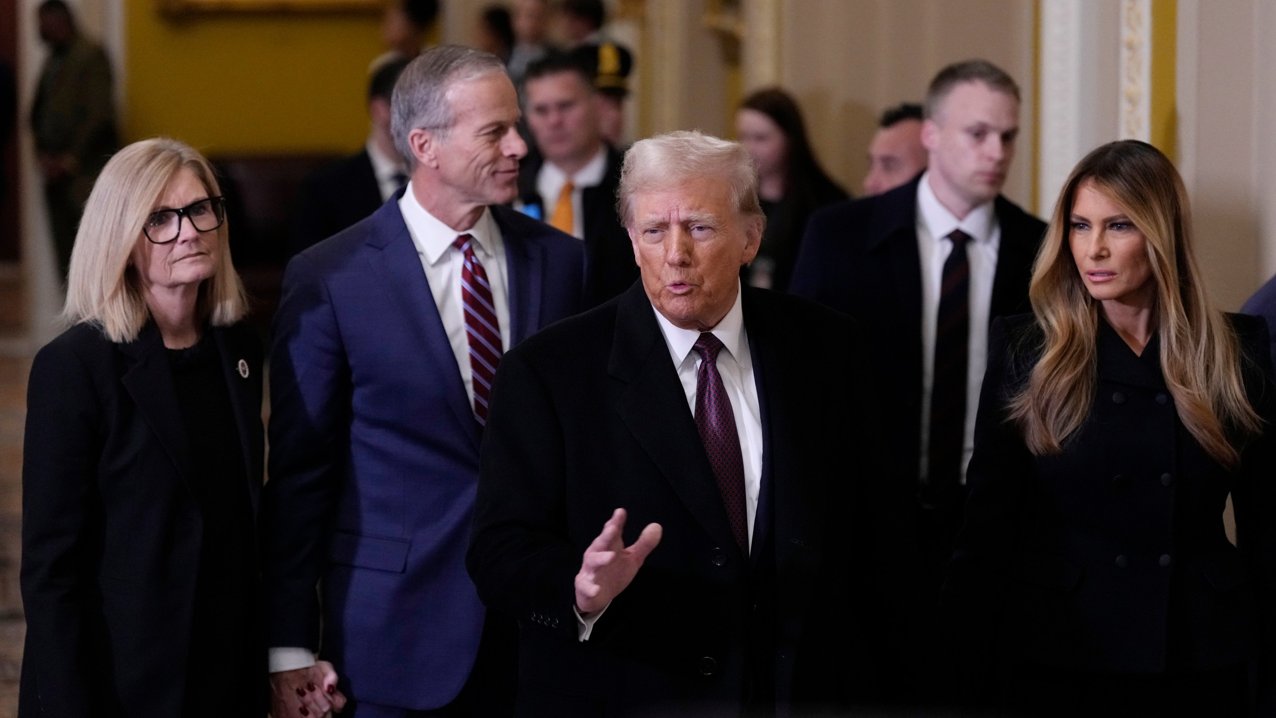 President-elect Donald Trump, center, and his wife Melania, walk with Majority Leader John Thune, R-S.D., and his wife, Kimberley, to meet with Senate Republican at the U.S. Capitol, Wednesday, Jan. 8, 2025, in Washington. (AP Photo/Steve Helber)