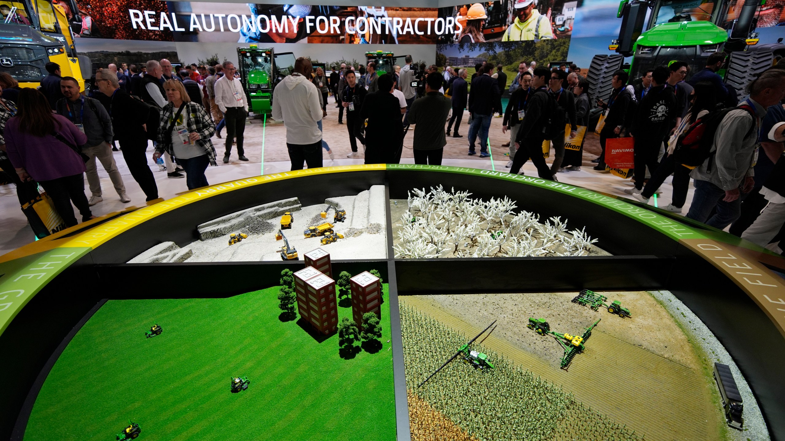 People visit the John Deere booth during the CES tech show Tuesday, Jan. 7, 2025, in Las Vegas. (AP Photo/John Locher)