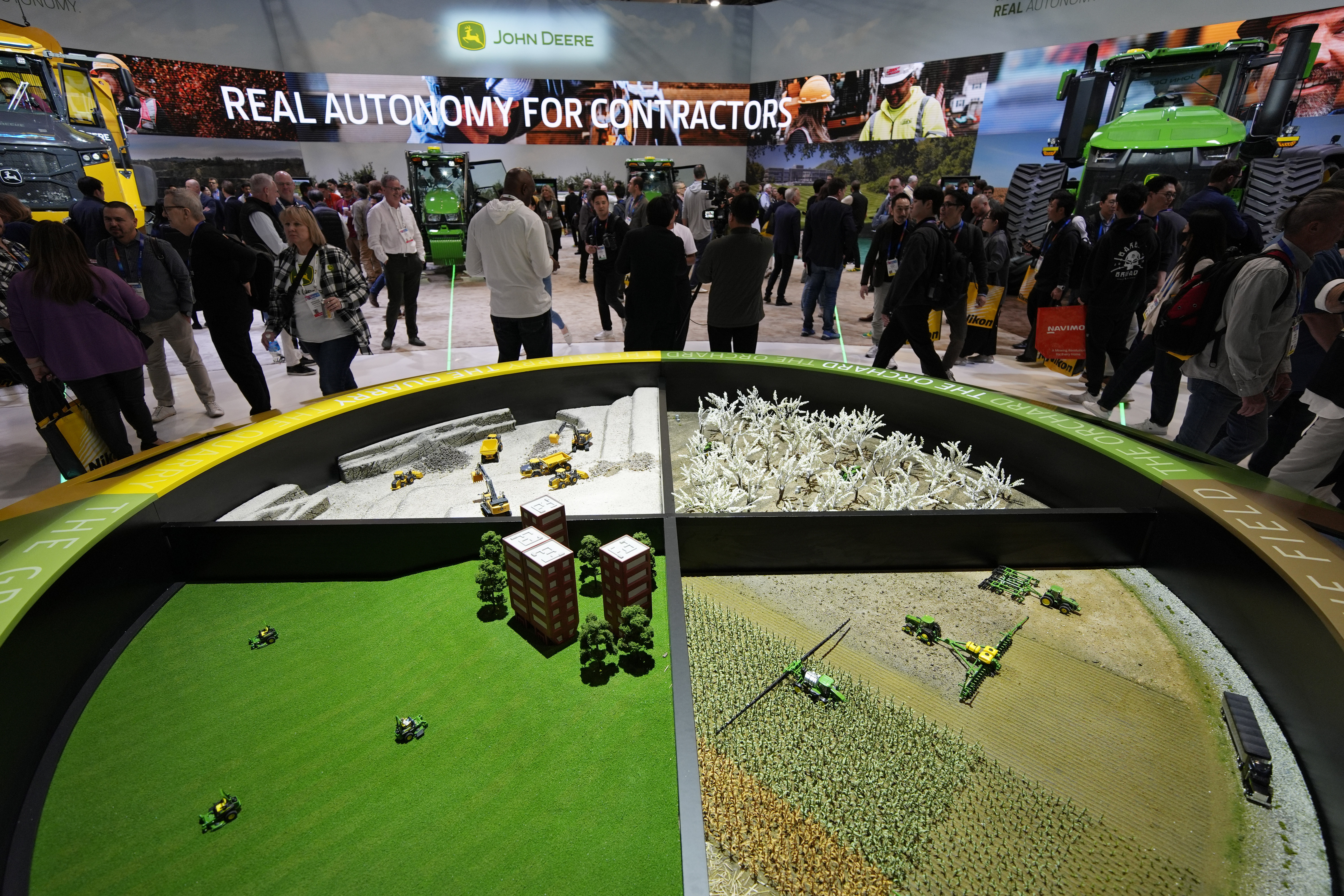 People visit the John Deere booth during the CES tech show Tuesday, Jan. 7, 2025, in Las Vegas. (AP Photo/John Locher)