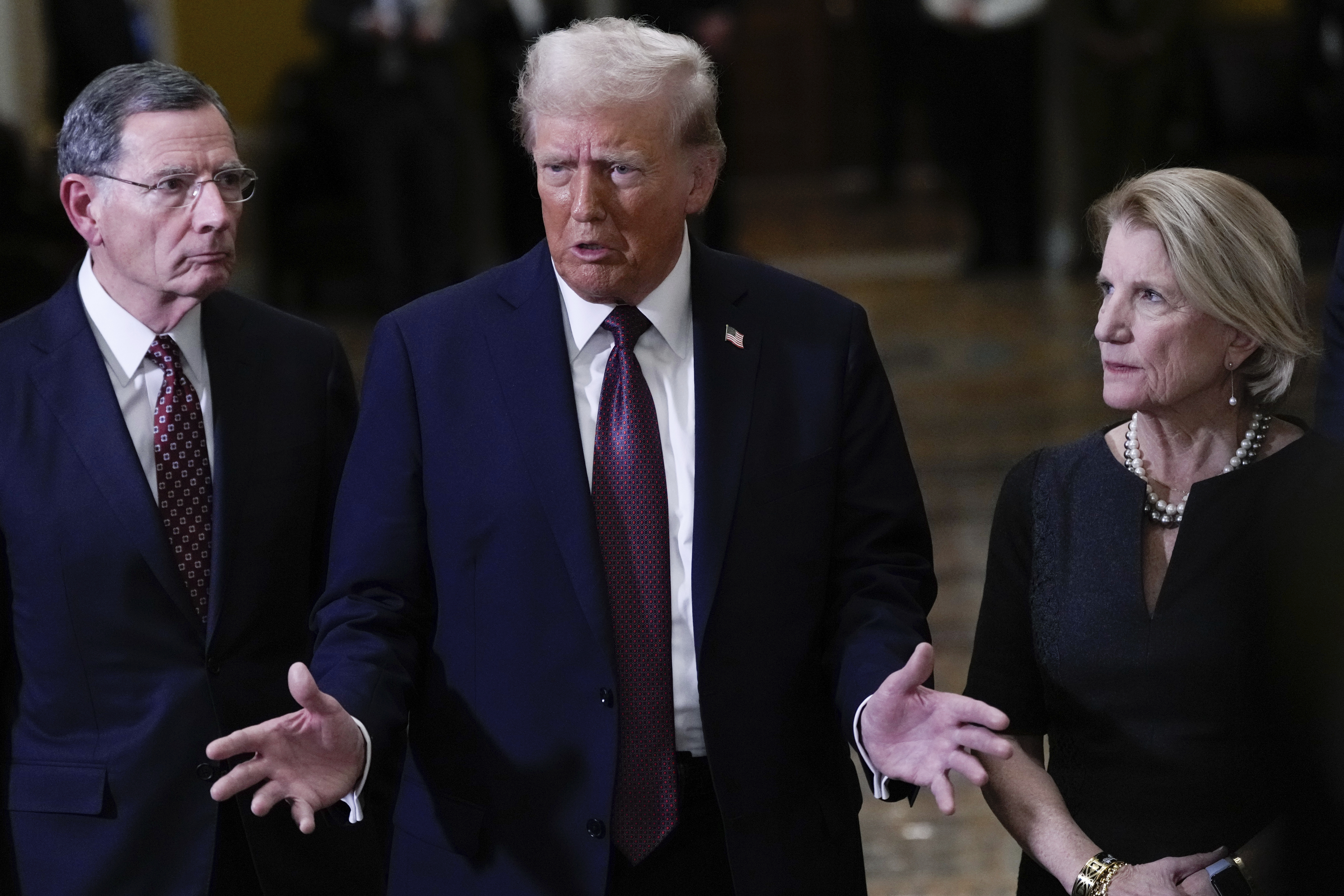 President-elect Donald Trump, flanked by Sen. John Barrasso, R-Wyo., left, Sen. Shelley Moore Capito, R-W.Va., right, talks to reporters after a meeting with Republican leadership at the Capitol on Wednesday, Jan. 8, 2025, in Washington. (AP Photo/Steve Helber)