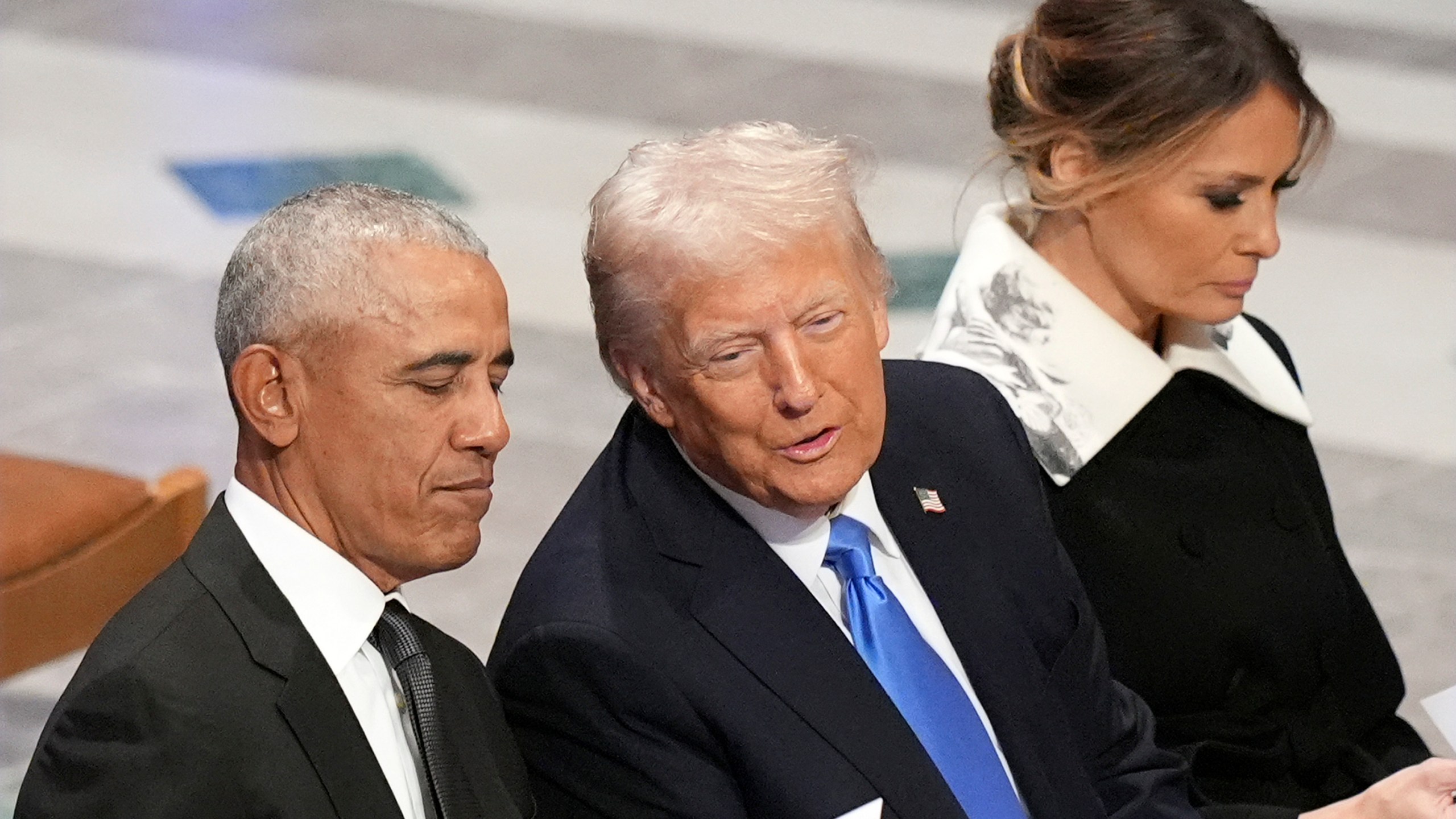 Former President Barack Obama talks with President-elect Donald Trump as Melania Trump reads the funeral program before the state funeral for former President Jimmy Carter at Washington National Cathedral in Washington, Thursday, Jan. 9, 2025. (AP Photo/Jacquelyn Martin)