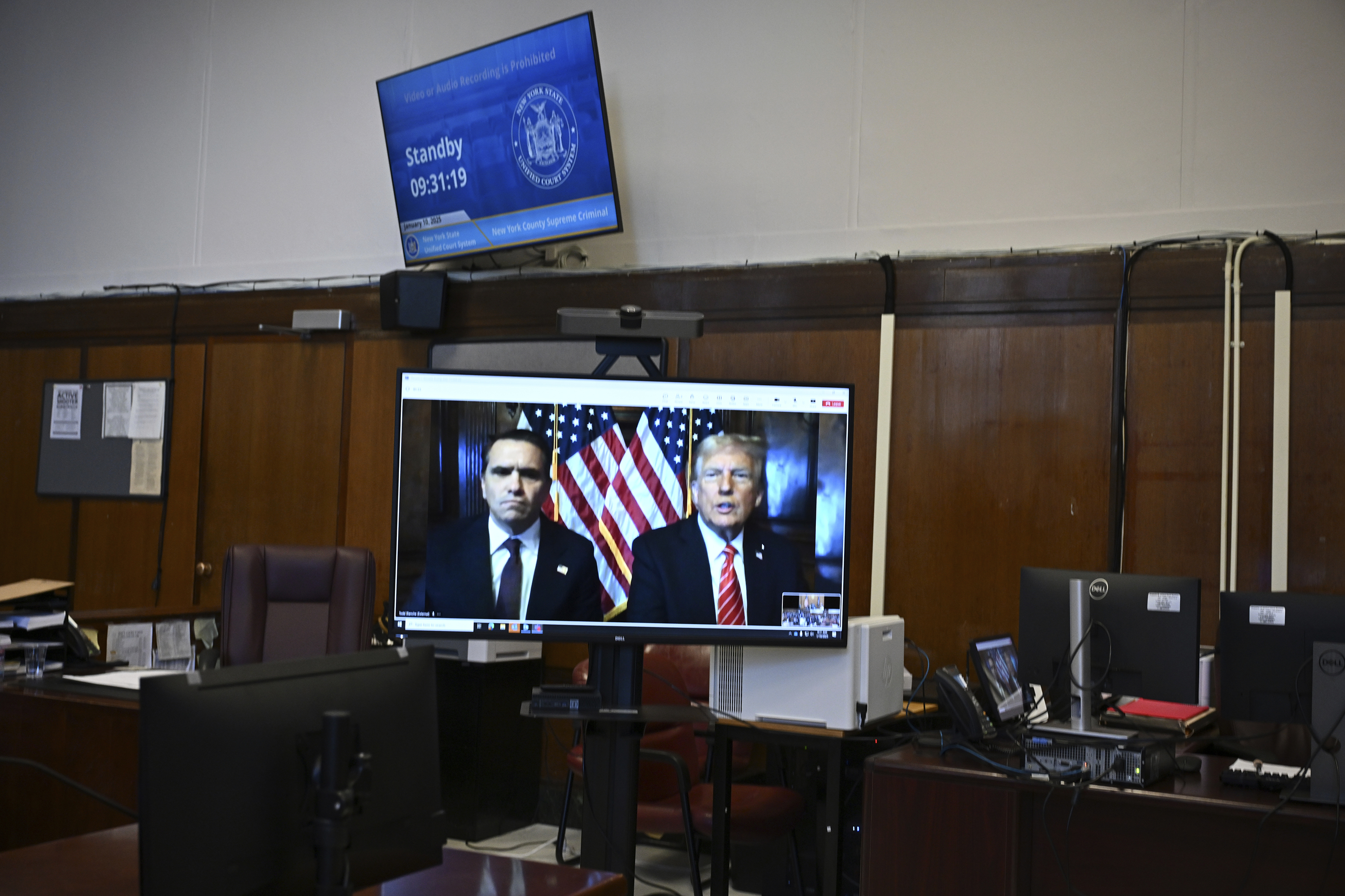 Attorney Emil Bove, left, listens as attorney Todd Blanche and President-elect Donald Trump, seen on a television screen, appear virtually for sentencing for Trump's hush money conviction in a Manhattan courtroom on Friday, Jan. 10, 2025 in New York. (Angela Weiss/Pool Photo via AP)