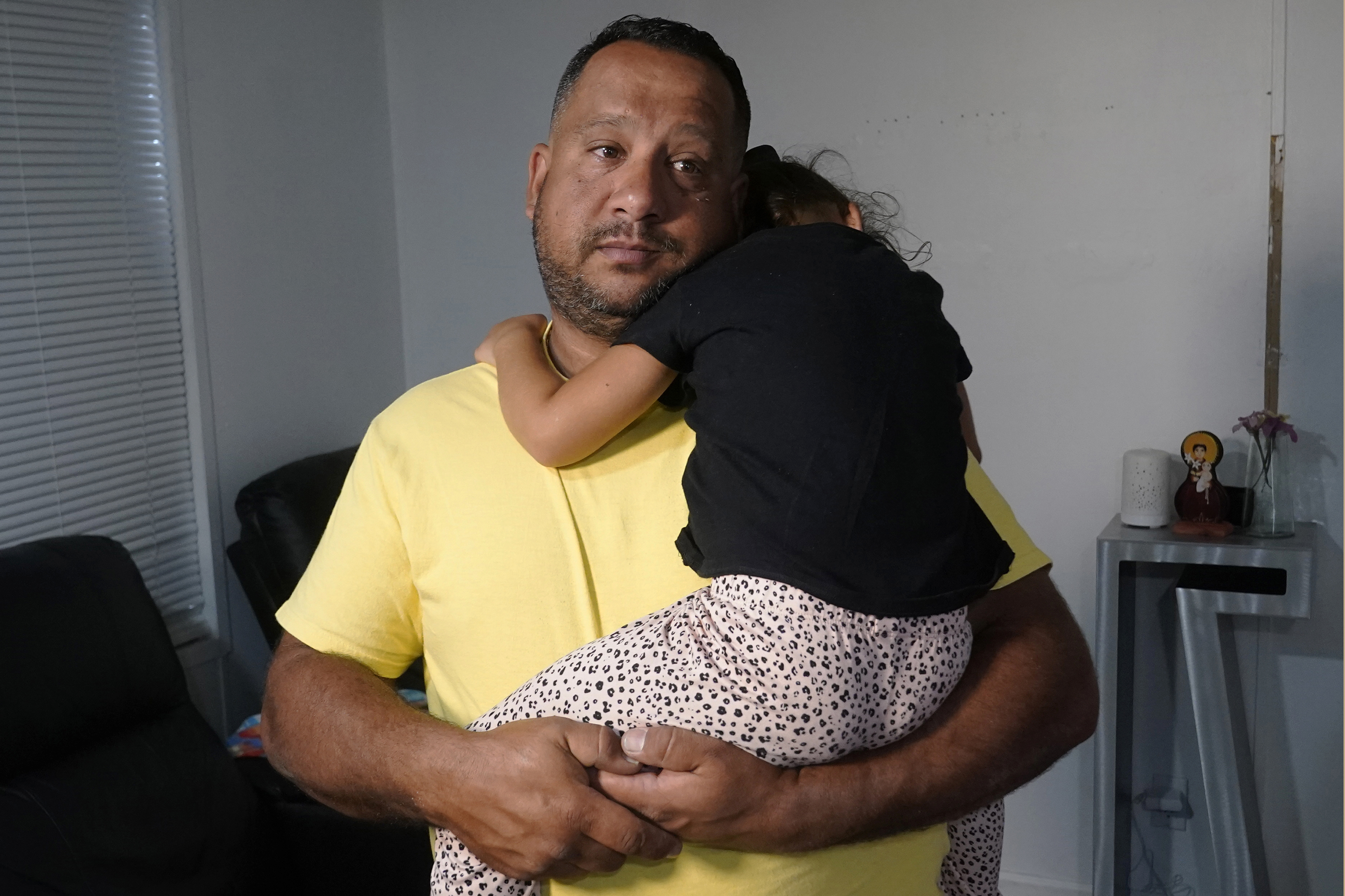 FILE - Venezuelan Victor Macedo holds his daughter Sonia at their home, in in Davie, Fla., Sept. 27, 2023. The family crossed the border U.S. almost two years ago. Since then, they have been living in South Florida with the support of family and friends. They recently qualified for temporary protected status. (AP Photo/Marta Lavandier, File)