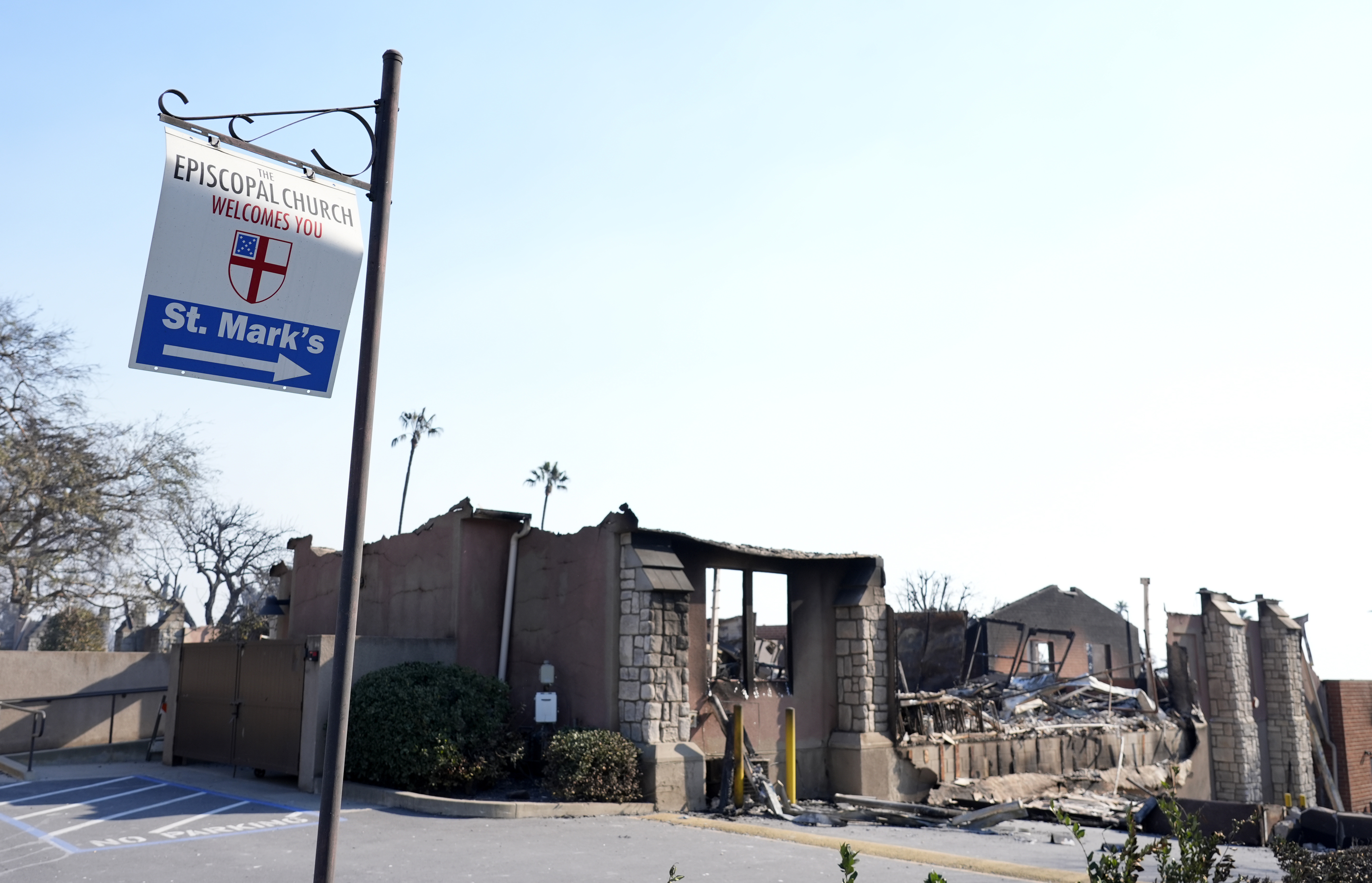 A welcome sign points to the charred remains of St. Mark's Episcopal Church after it was destroyed by the Eaton Fire, Friday, Jan. 10, 2025, in Altadena, Calif. (AP Photo/Chris Pizzello)